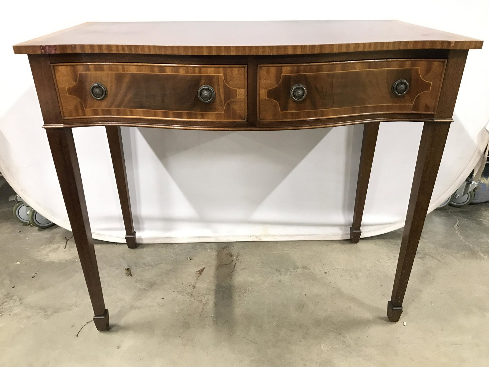 Vintage Carved Wooden Entryway Table W Drawers: Entryway table is vintage and wooden. Piece includes 2 drawers each with 2 gold toned brass loop style handles. Table also has carved wooden feet. Table appears to possibly have inlaid detail. Piece m