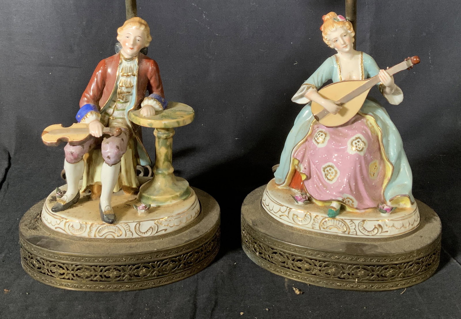 Pair LEVITON Rococo Style Lamps: Pair Rococo style lamps, inscription to piece reads ‘Leviton 660 W 250 V’ and ‘Press’, a man and woman in French clothes playing instruments, both measure 13 3/8 inches tall x 7 inches wide at