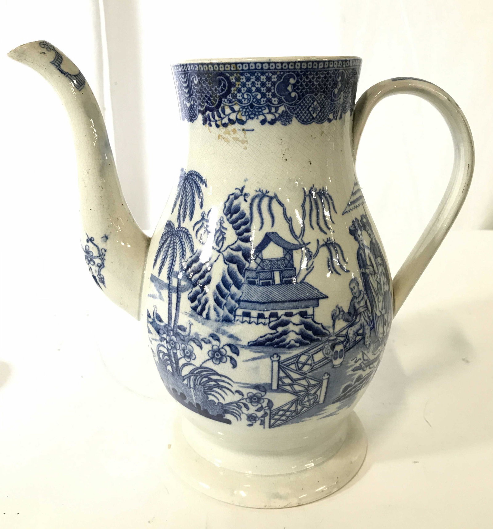Antique Porcelain Coffee Pot: Coffee pot is porcelain and antique. Piece is white with blue toned floral, leaf, vine and landscape detail. Piece measures approximately 8.5 inches tall 9 inches wide with handle and spout 5 inches d