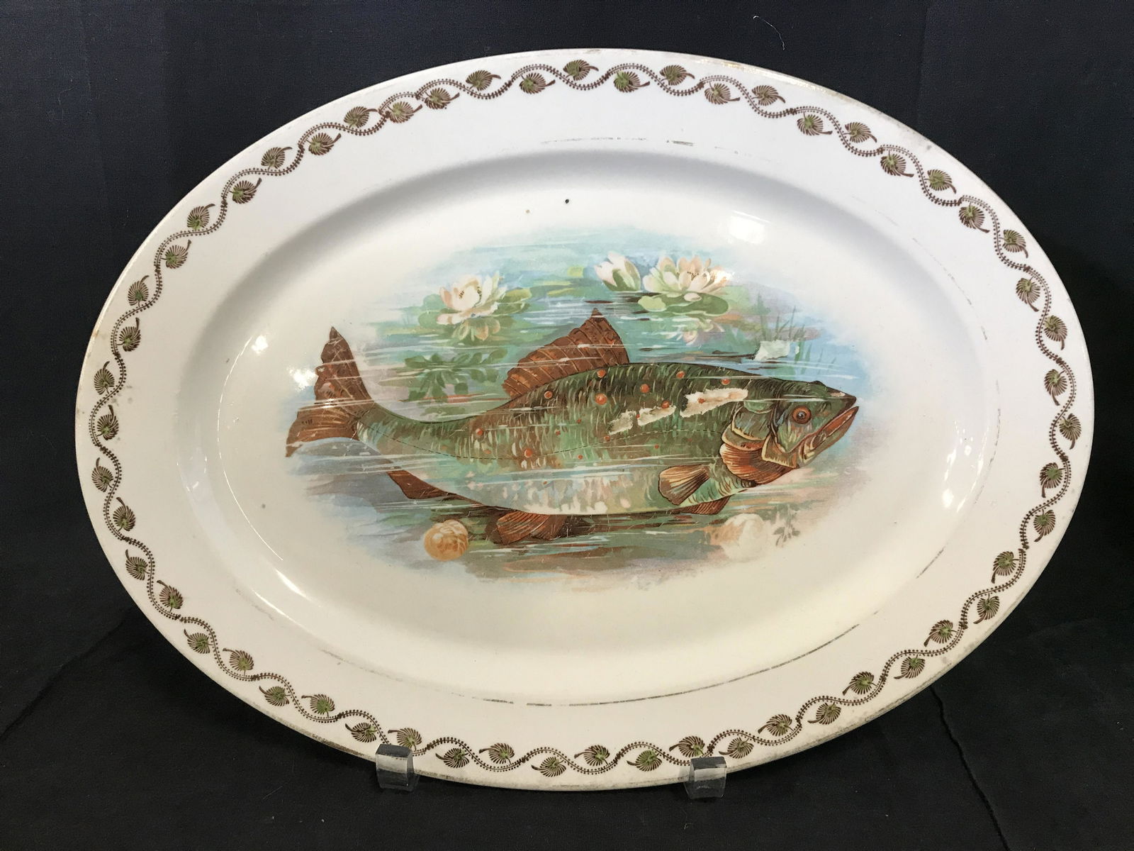 AUSTRIAN DECOR Trademarked Fish Plate: Plate, trademarked on underside as AUSTRIAN DECOR. Well of plate is decorated with a print of a fish, the lip is handpainted with leaf like detailing. Measures approx 16 inches Long, and 11.5 inches W