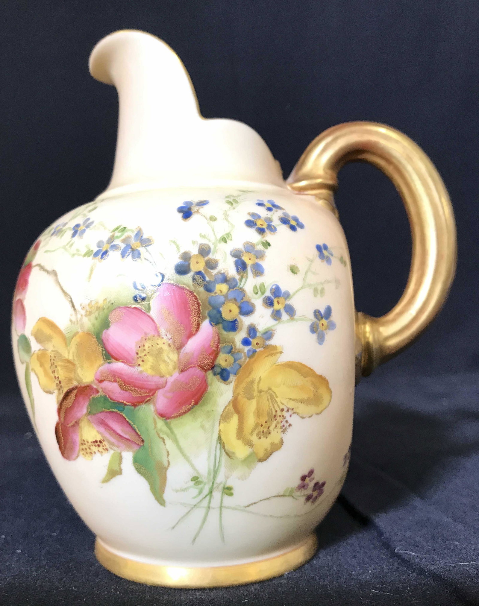 ROYAL WORCESTER Porcelain Pitcher: Underside is marked ROYAL WORCESTER. Pitcher is porcelain possibly vintage. Piece has intricate multi toned floral, leaf and vine detail. Piece has gold toned handle. Measures approximately 5.5 inches