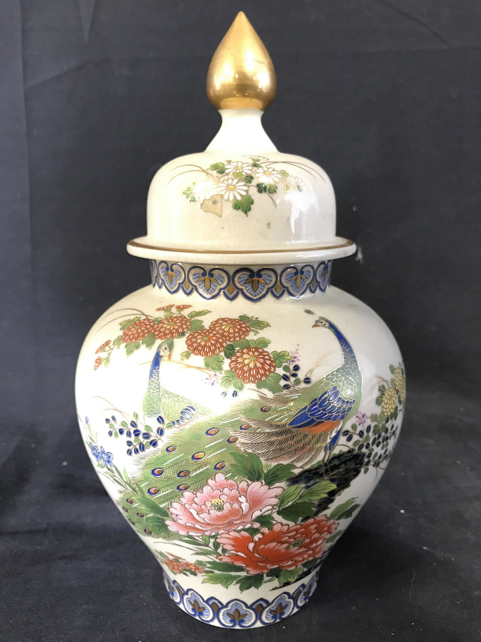 Signed Asian Ginger Jar With Lid: Underside of piece is signed. Ginger jar is porcelain. Piece has intricate multi toned floral, leaf, & bird detail. Ginger jar includes lid. Piece measures approximately 12 inches tall 6.5 inches wide