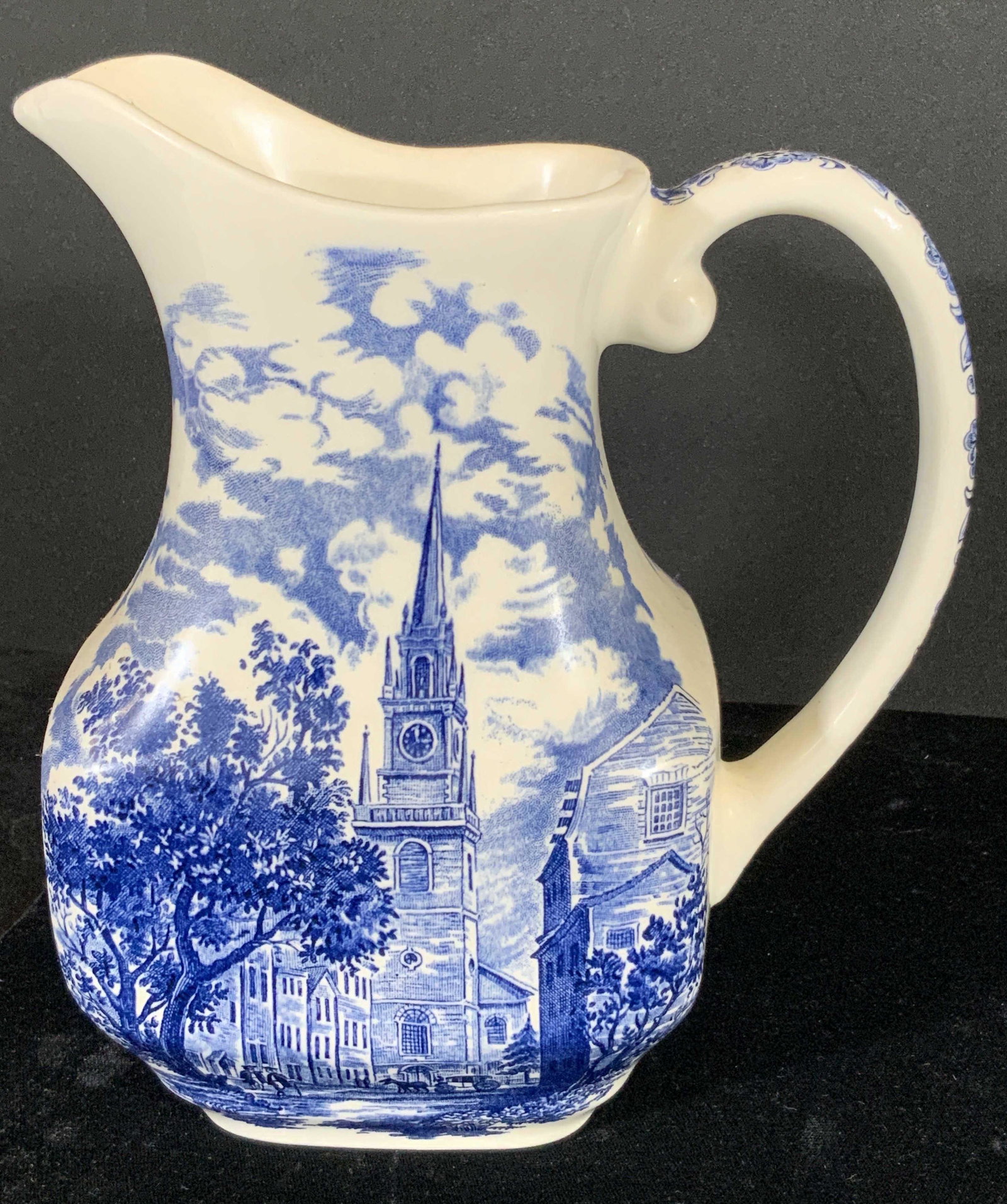 LIBERTY BLUE Sig. Historic Colonial Scenes Pitcher: Trademarked and signed collectible blue and white porcelain pitcher. The pitcher is white porcelain with blue scenes depicting nature and the Old North Church. The handle has blue nature motif designs