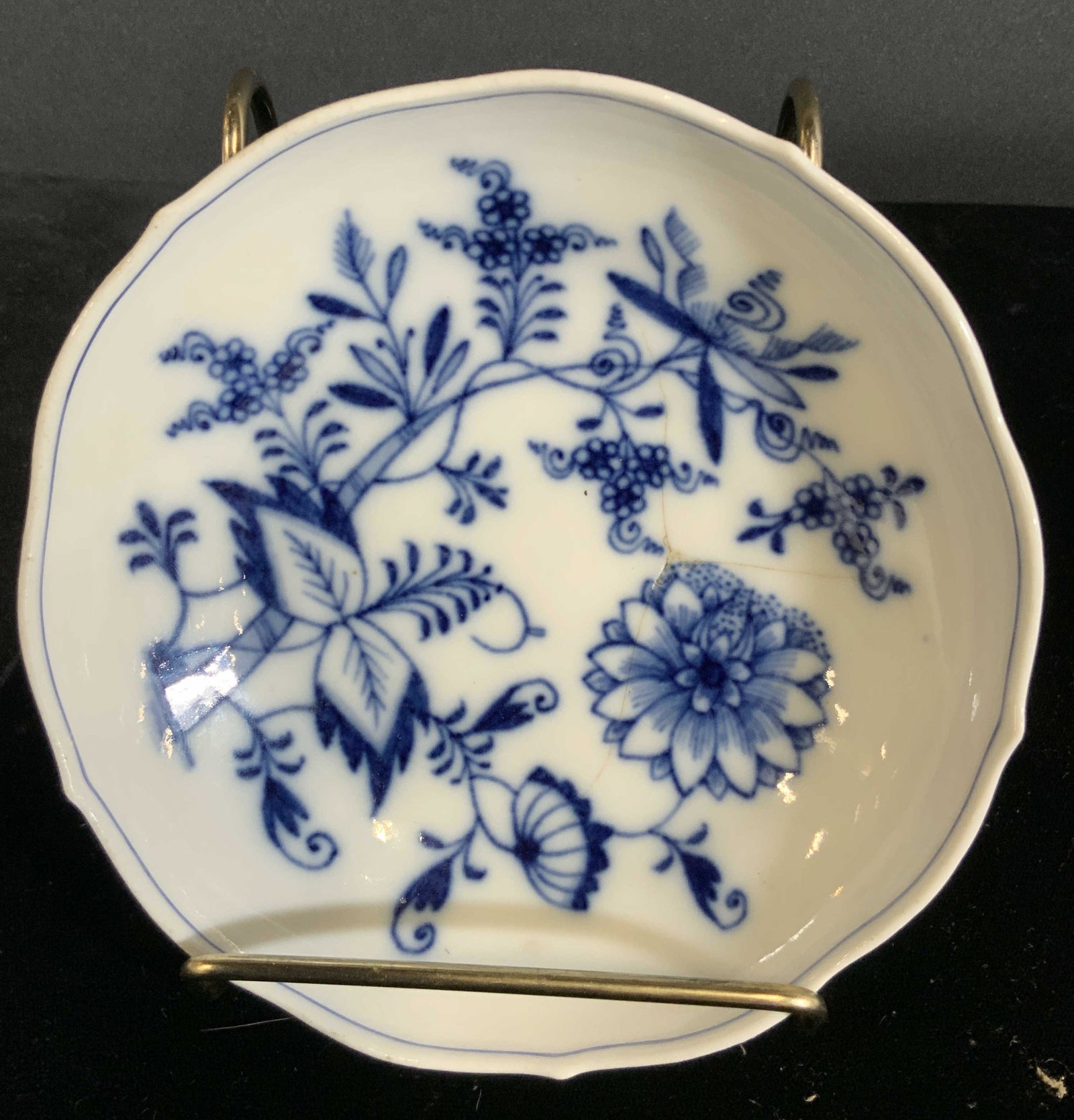 MEISSEN Signed White & Blue Porcelain Trinket Dish: White porcelain trinket dish / saucer with intricate blue floral designs. Large and small flowers surrounded by leaves and vines. Slightly scalloped rim. Underside trademarked with Meissen trademark. 