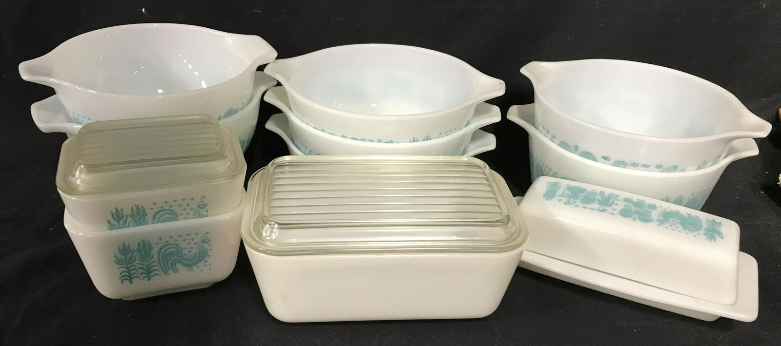 PYREX Trademarked 14pc Ovenware: 14 pc ovenware by PYREX. Butter print Pyrex dishes, depict turquoise farmer print on white base, one piece hosts a pink print. Largest piece Measures approx 3.25 inches H, and 7.5 inches W. Wear is co