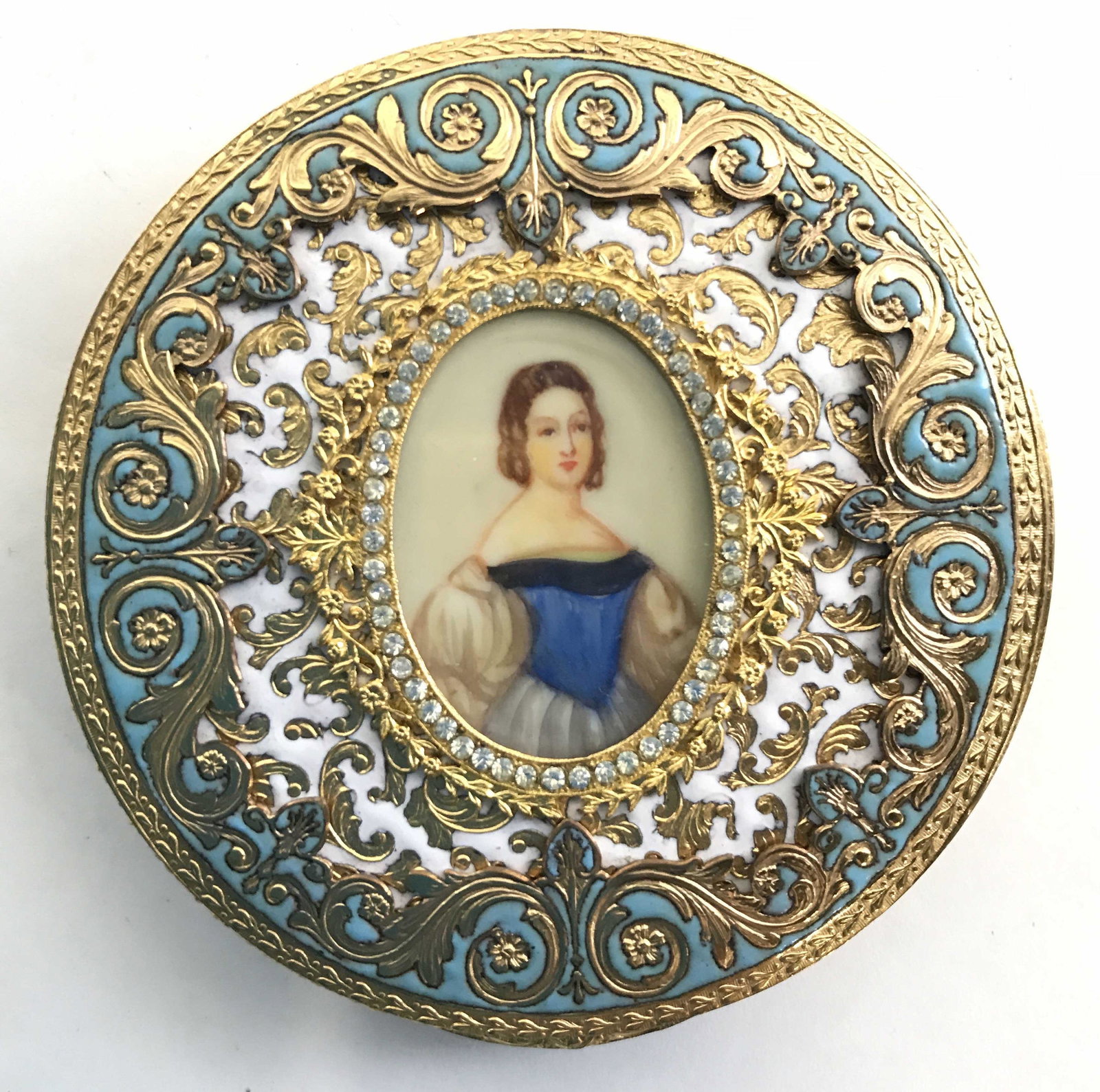 ESTEE LAUDER Ornate Vintage Compact Mirror: Powder puff inside compact is marked ESTEE LAUDER. Underside of lid is mirrored. Compact has intricate ornate detail w portrait of female figure at center. Piece measures approximately 3 inches wide. 