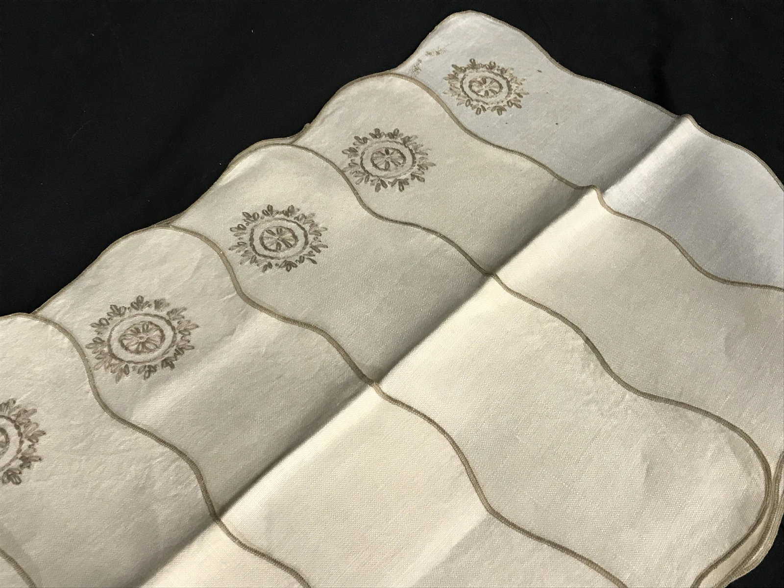 Set 8 Embroidered Table Linens: Set of 8 embroidered table linens, cream colored base, beige embroidery. Includes a table cloth and 7 placemats. Measures approx 100 inches Long, and 60 inches W. Wear is consistent with age and use, 