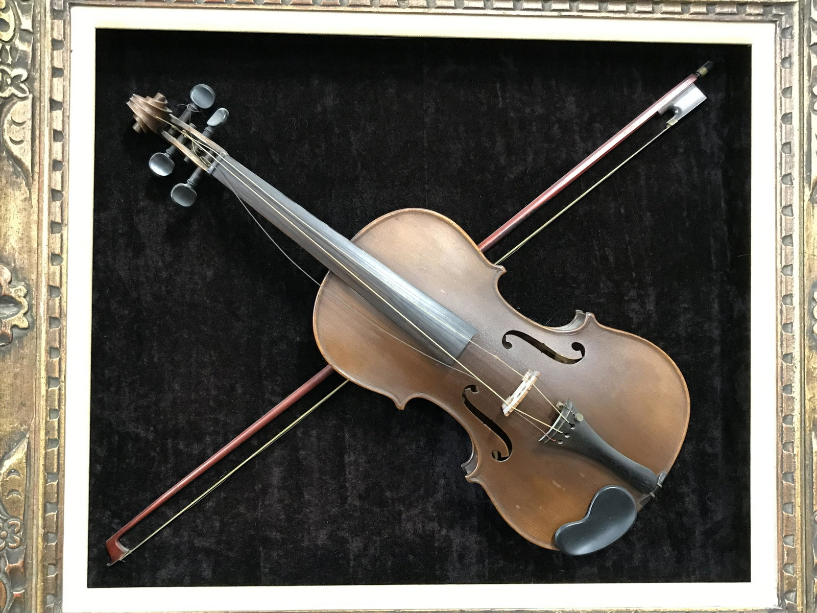 Mounted Violin and Bow Shadowbox Display: Mounted Violin and bow shadowbox, subject a violin and bow mounted on brown velvet, shadow box made of gilt wood, yellow linen inner frame, measures 27 inches at tallest point and 31 inches at widest,
