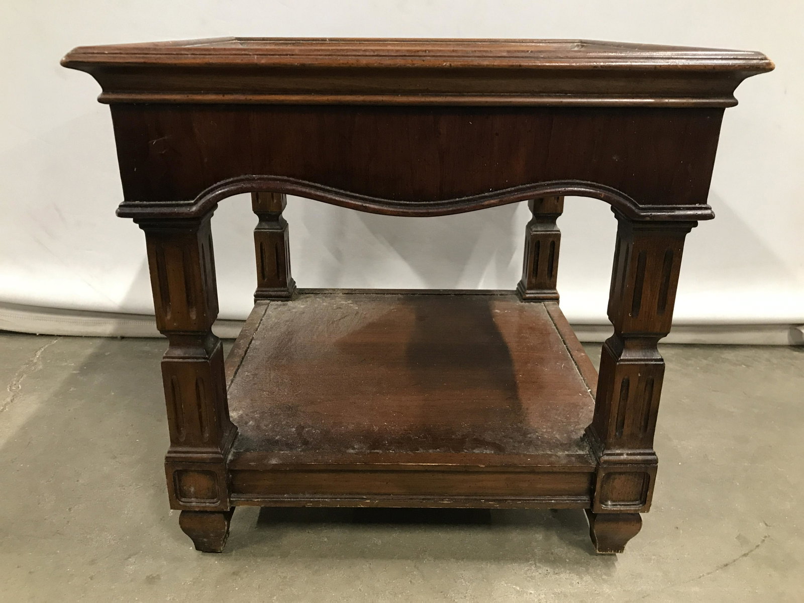 Vintage Low Carved Wooden Side Table: Side table is vintage and wooden. Table legs have carved wooden detail. Legs have board style stretcher in between legs. Piece measures approximately 17.5 inches tall & square. Side table, end table, 