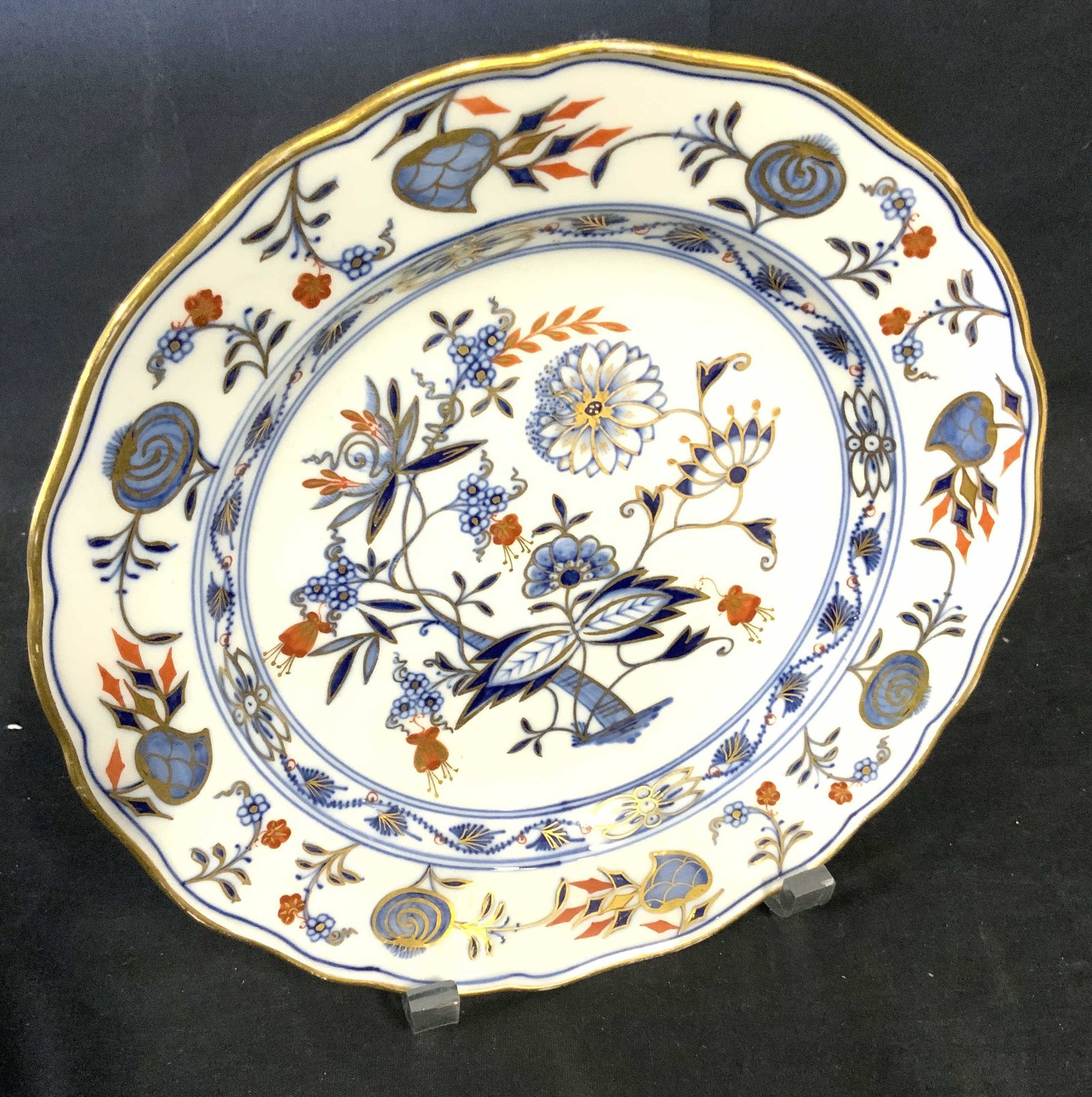 MEISSEN Trademarked Gilt & Blue Porcelain Plate: DRESDEN MEISSEN PLATE, decor all outlined ingilt, possibly 22kt gilt. White porcelain with blue florals , touches of orange florals. Wavy rim, solid gilt edge. Verso with Meissen sword trademark, hand