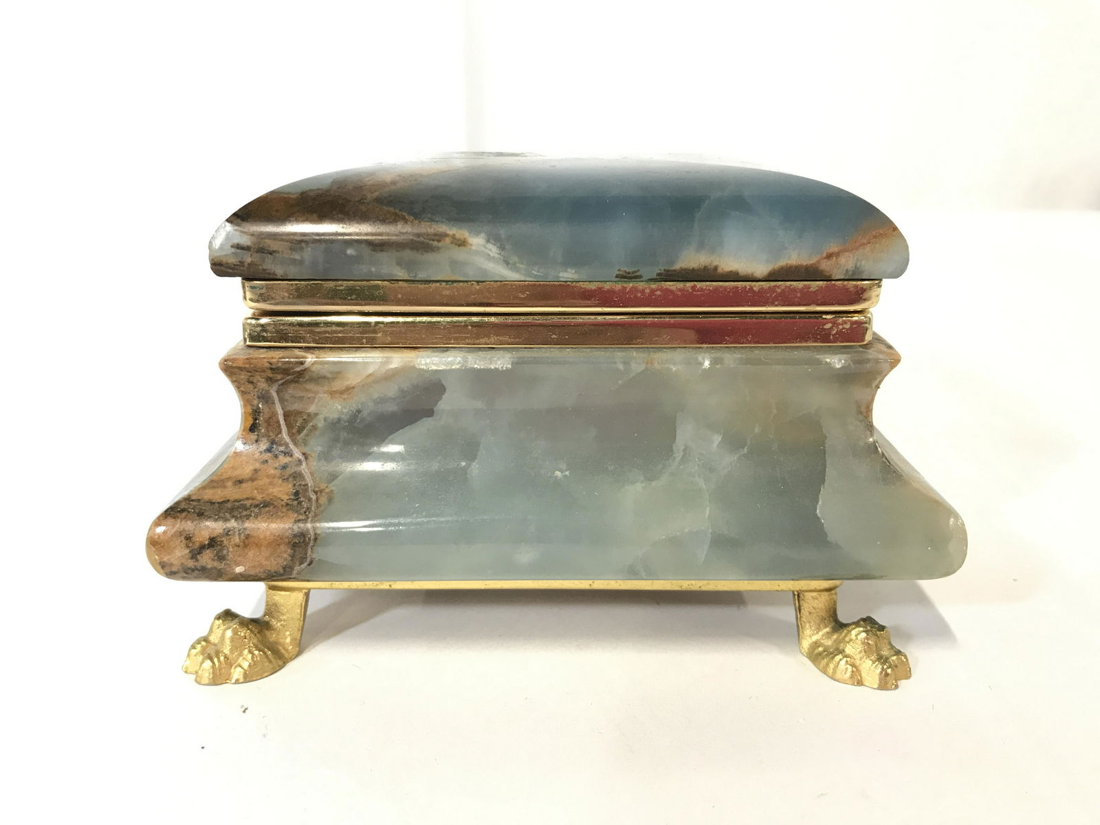 Carved Stoned Footed Keepsake Box: Keepsake box appears to be stone possibly marble. Piece has gold toned claw style feet. Interior is lined with red toned fabric. Piece measures approximately 5 inches long 4 inches deep 3 inches tall.