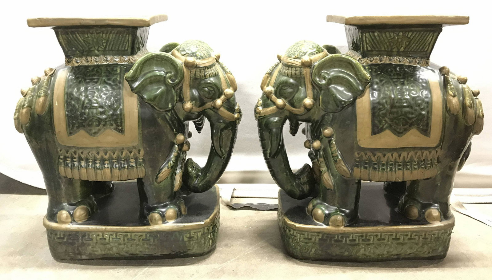 Pair Vintage Asian Porcelain Elephants Stools: Lot includes 2 Porcelain Elephant figures. Each are green and gold toned. Each appear to possibly be handmade. Pieces appear to be planter pedestals. Each can be stand alone piece. Each measures appro