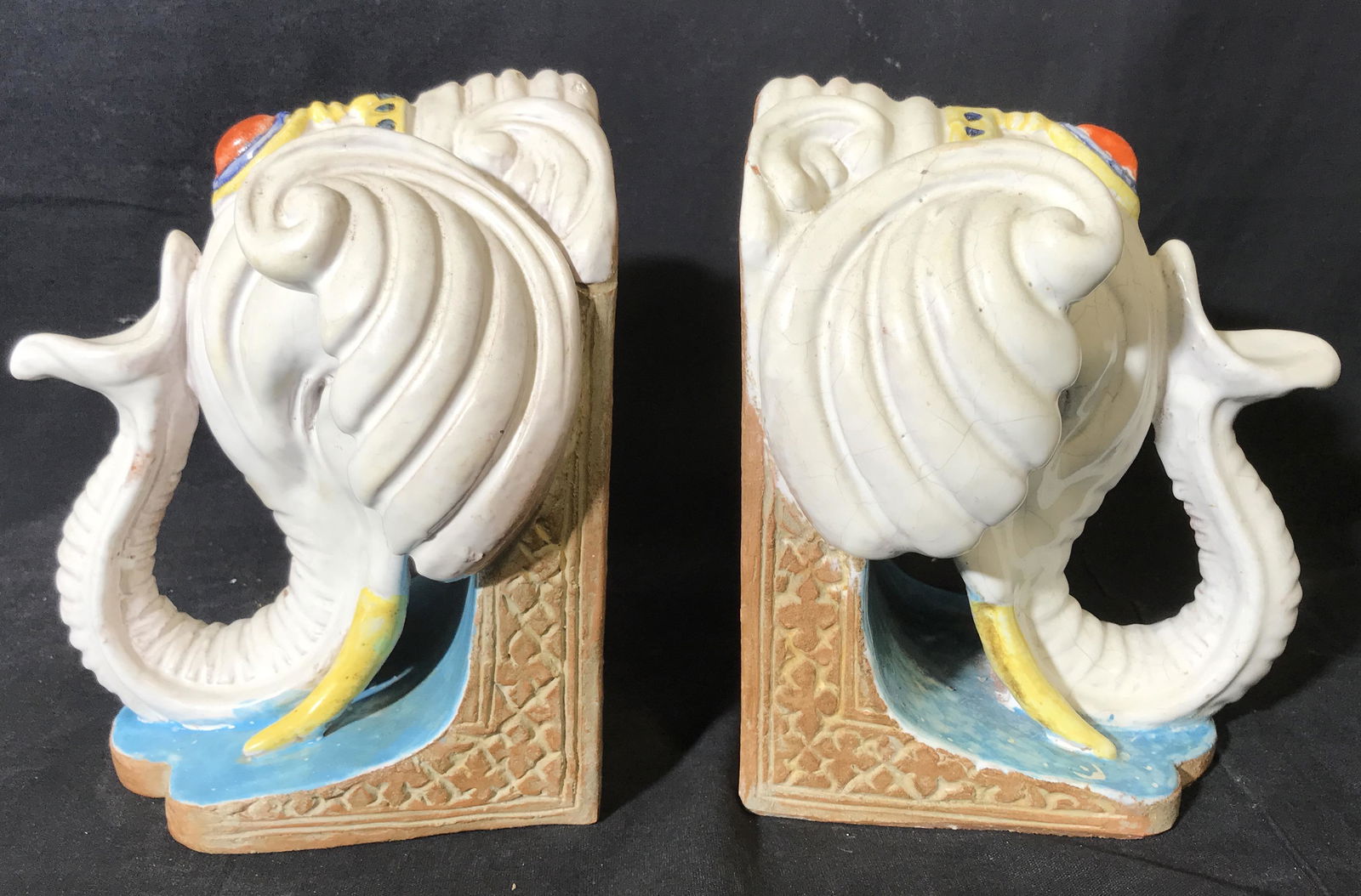 Pair Ceramic Elephant Bookends: Pair Ceramic Elephant Bookends, no apparent stamps or signatures to either, both display a white elephant head with yellow tusks a red gem on the forehead and a blue background, heavy weight objects,