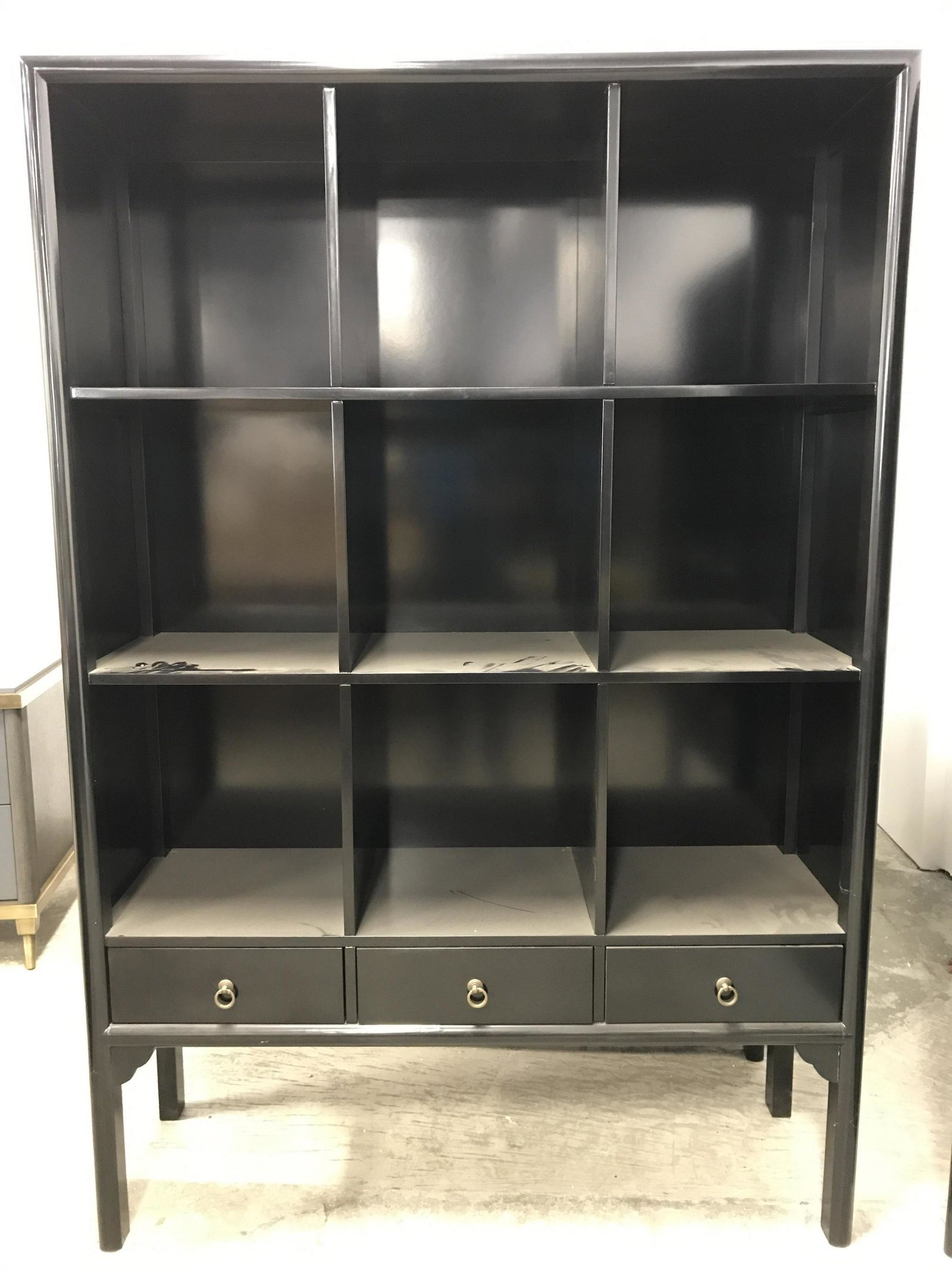 Vintage Wooden Lacquered Shelves: Wooden shelf display case. 9 shelves, three drawers, each drawer has a brass drawer pull. Black lacquered finish. Measures approx 76.75 inches H, 52 inches W, and 16.5 inches deep. Wear is consistent 