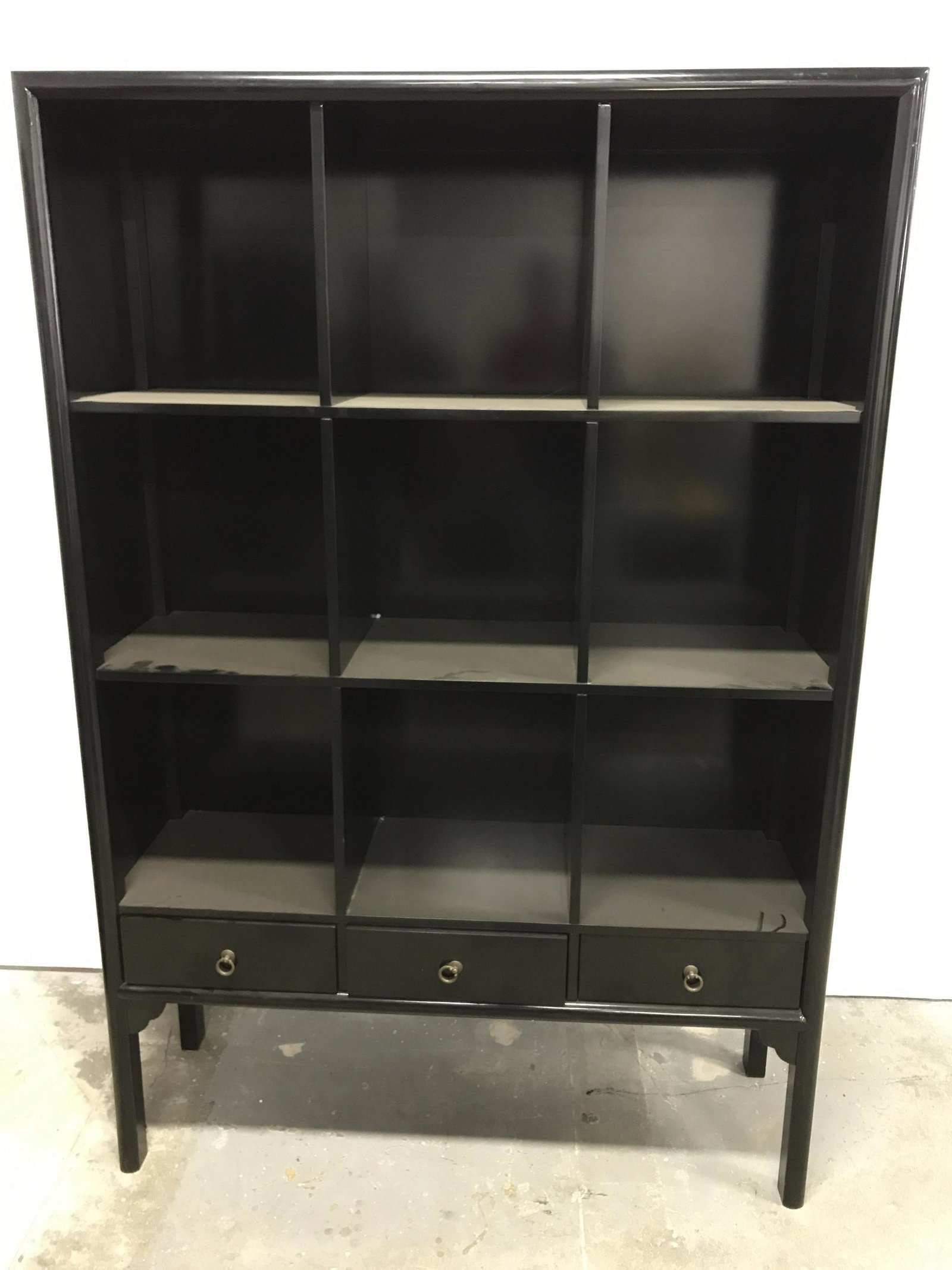 Vintage Wooden Lacquered Shelves: Wooden shelf display case. 9 shelves, three drawers, each drawer has a brass drawer pull. Black lacquered finish. Measures approx 76.75 inches H, 52 inches W, and 16.5 inches deep. Wear is consistent 