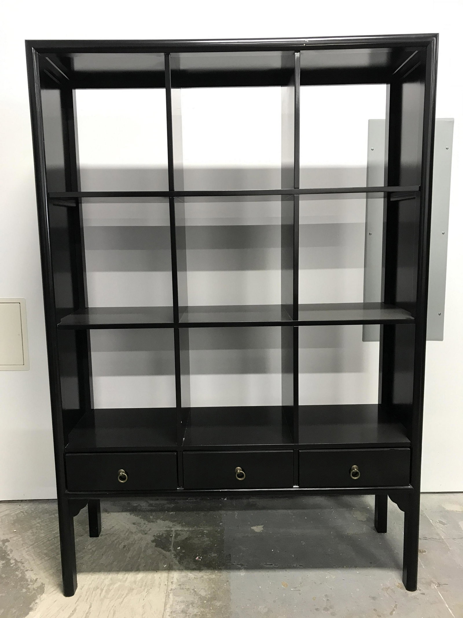 Vintage Wooden Lacquered Shelves: Wooden shelf display case. 9 shelves, three drawers, each drawer has a brass drawer pull. Black lacquered finish. Measures approx 76.75 inches H, 52 inches W, and 16.5 inches deep. Wear is consistent 