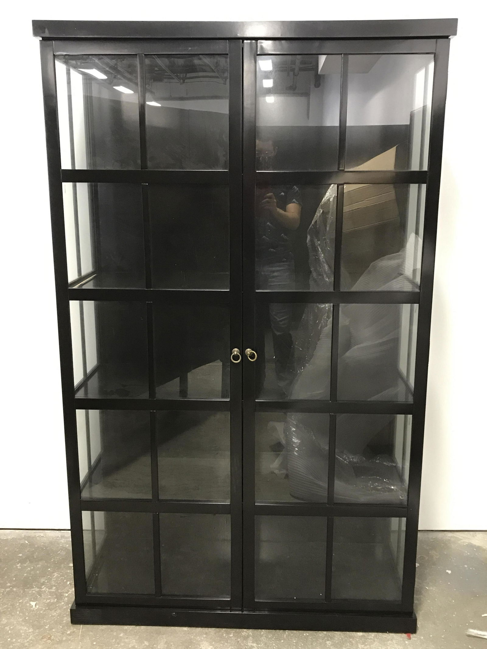 Vintage Lacquer Display Case: Vintage wooden display case. Sides and doors are windowed. Door pulls are crafted from brass. Case is finished in black lacquer. Measures approx 80 inches H, 49 inches W, and 18.25 inches deep. Wear i