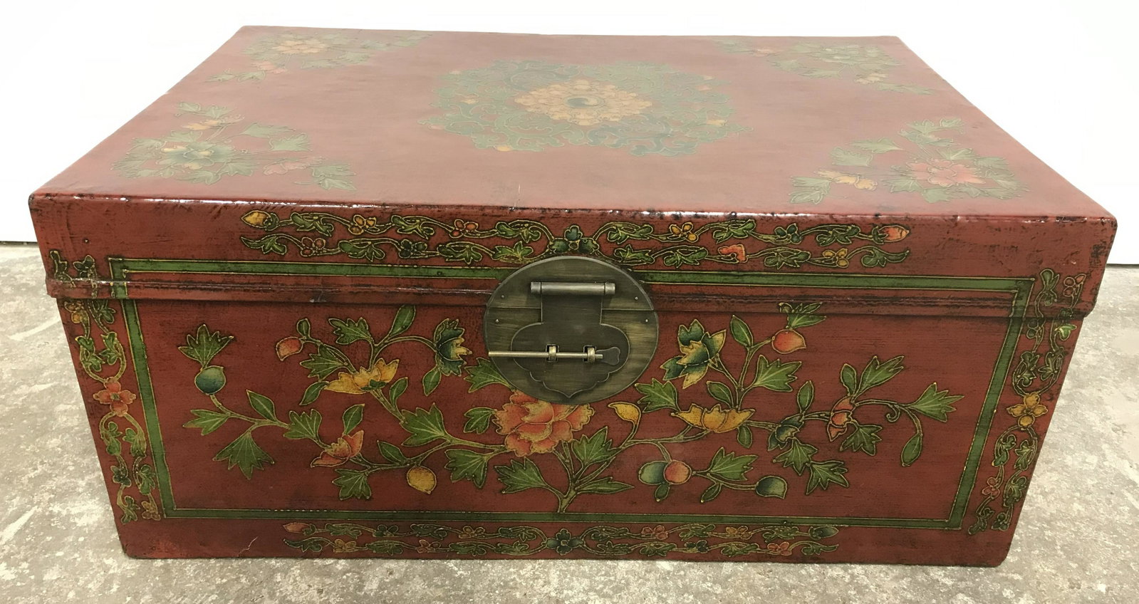 Hand Painted Asian Style Chest: Hand painted wooden chest, hand made, and vintage, possibly antique. Possibly treated leather on wood. Vermillion toned, decorated by multi toned floral pattern. Metal handles on each side, lid can be