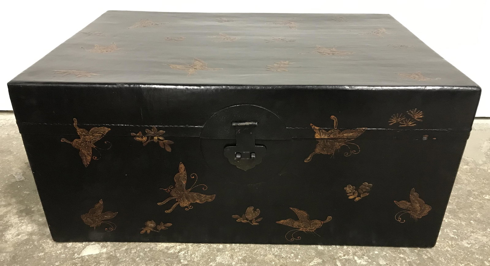 Vintage Asian Leather & Wood Chest: Hand painted wooden chest, hand made, and vintage, possibly antique. Possibly treated leather on wood. Black exterior, decorated with copper toned butterflies among flowers. Metal handles on each side