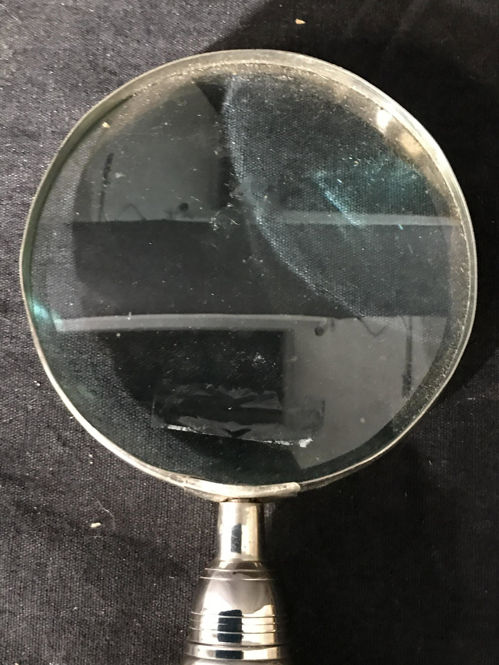 Metal Handle Magnifying Glass: Magnifying glass is has metal handle. Lower area of handle has beveled & relief detail. Handle is detachable from glass head. Piece measures approximately 12 inches tall 4 inches wide. Magnifying glas