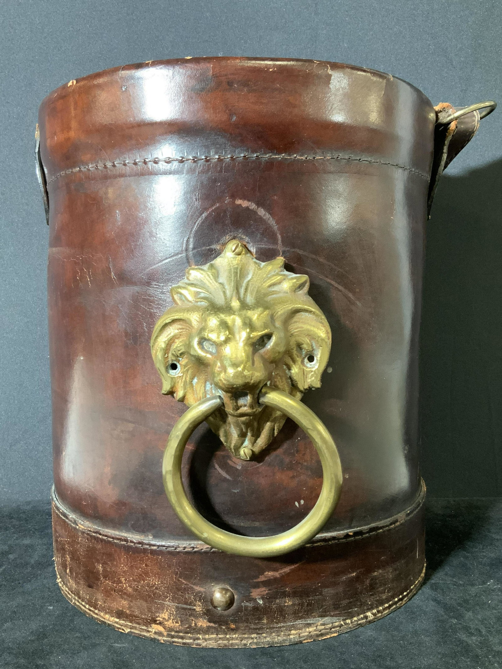 BROOKS BROTHERS Antique Leather Wrapped Ice bucket: Possibly antique Deep brown leather wrapped black metal pail with gold toned embossed lion head w/ ring. Antique condition. Strap needs repair, surface scratches in pail and leather. Lion head needs r