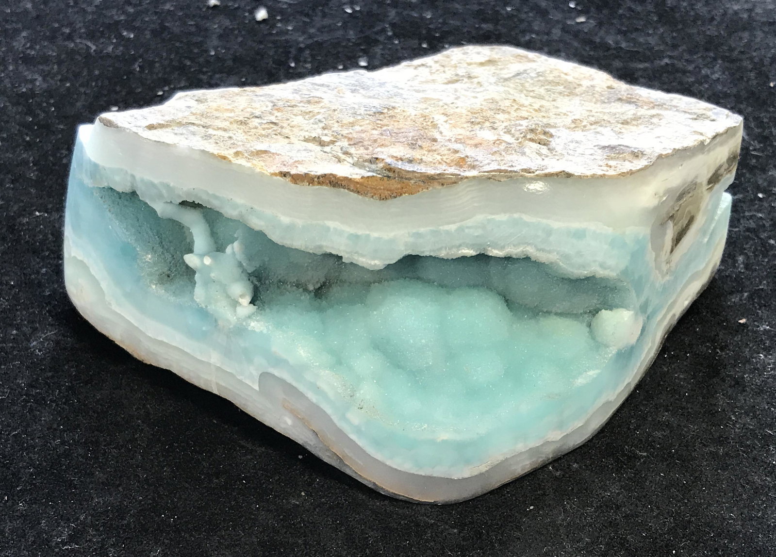 Peruvian Mined Aragonite Geode: Peruvian Mined Aragonite Geode, mined from the Moquega mine in Peru, unique in its own shape and size, a a druzy crystal with pale blues and whites, measures 2.25 inches at tallest and 4.25 inches at 