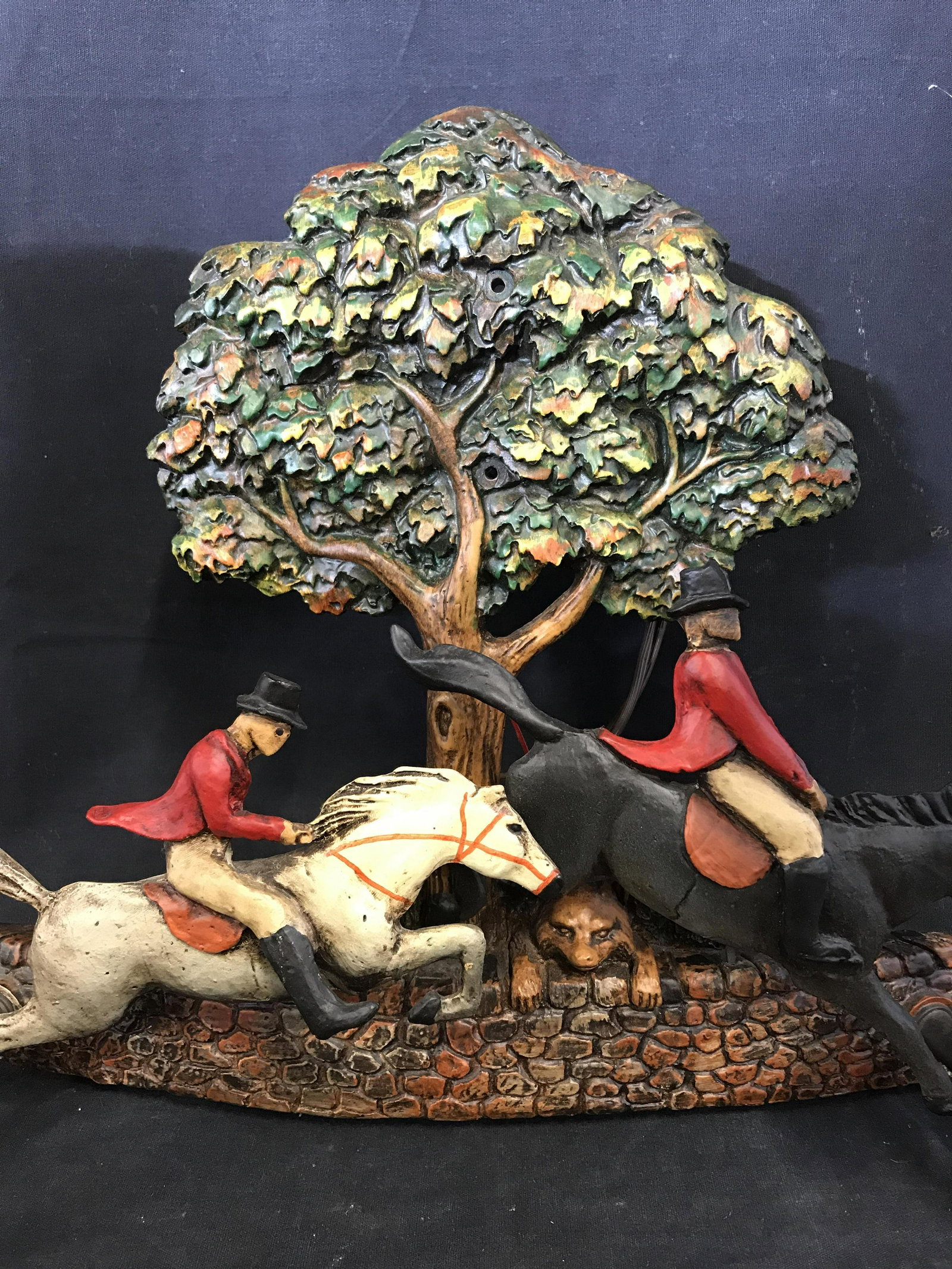 HUEBBE Signed Fox Hunt Wall Sconce: SIGNED HUEBBE fox hunt wall sconce. Depicts two hunters on horse back, a fox peers over a wall in the background. The sconce is crafted from carved wood, and is hand painted. Each socket resembles a d
