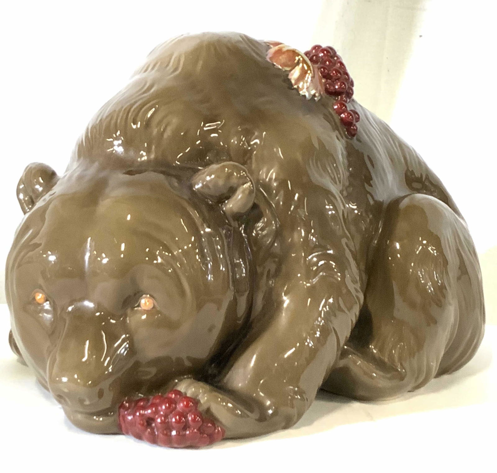 ZSOLNAY Signed Grape Bear Figural, Hungary: A large glazed brown bear figural with grapes and leaves atop it’s back. Grapes are deep red while the leaves are an orange hue. The bear is also eating from a grape bunch secured under it’s paw.