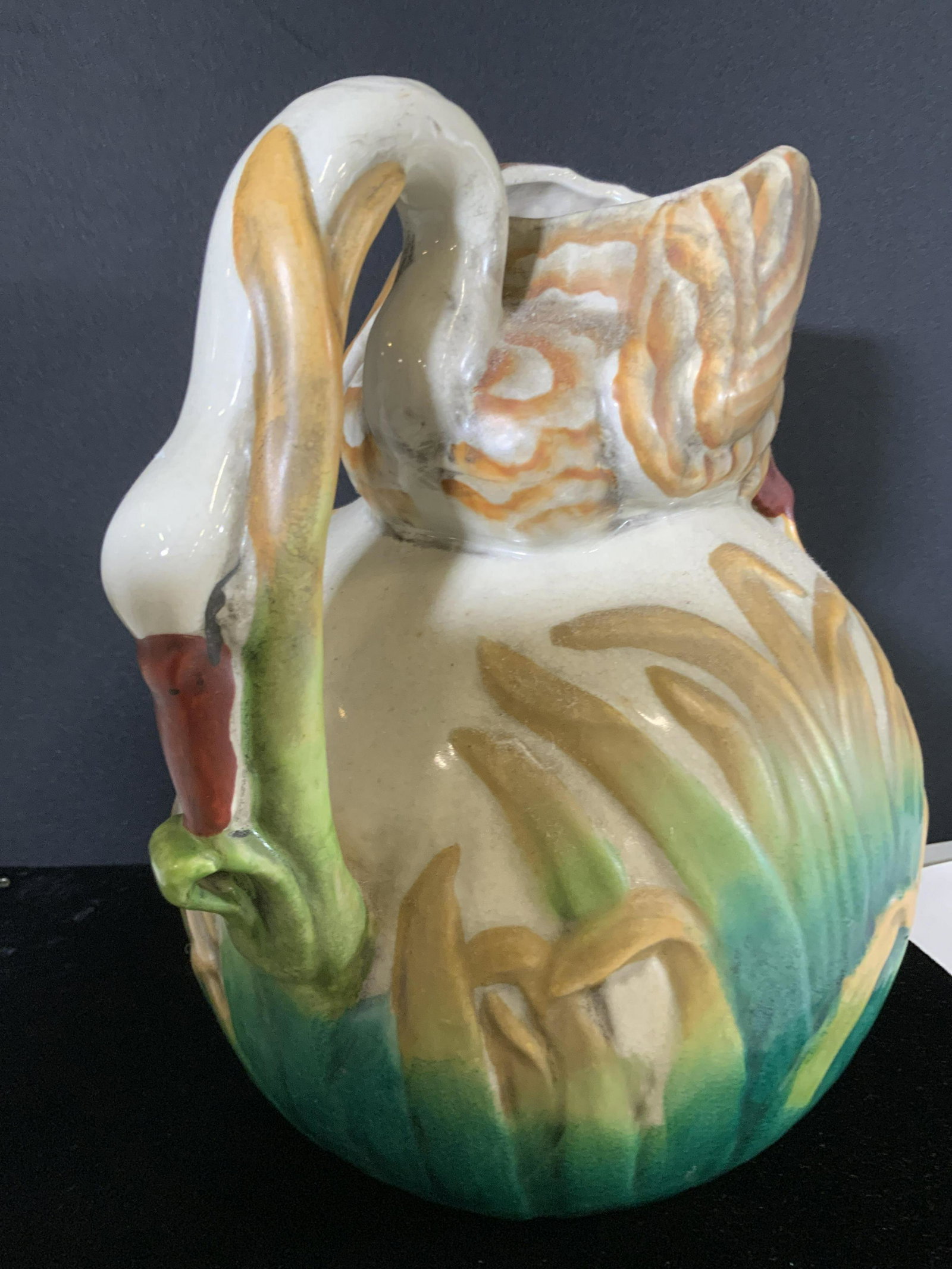 Signed MAJOLICA SWAN Pitcher Centerpiece: Ceramic Vintage Hand painted pitcher. Has marking on underside, appear to be worn. Swan/ Goose sits atop colorful green fading to yellow grass/ reeds with neck doubling as the handle and the body inco