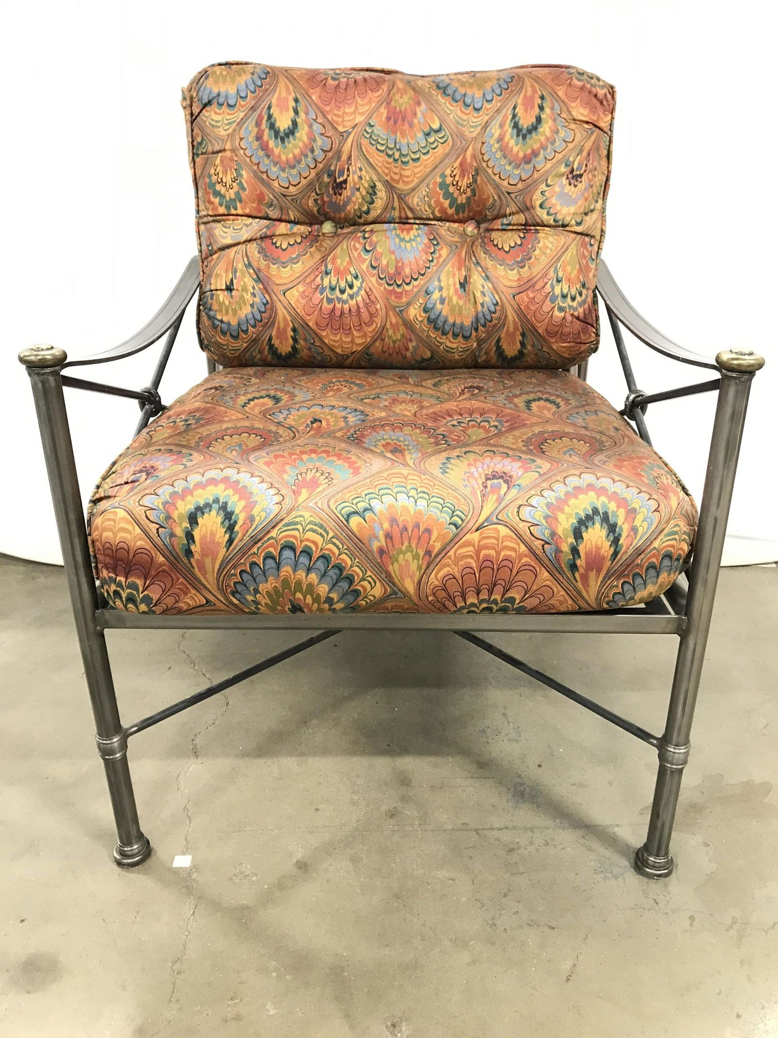 Set 2 WOODARD Steel Armchair & Ottoman: Chair and ottoman are steel. Each have black toned woven supports. Chair includes multi toned organic shape detail upholstered cushions underside Of ottoman has tag which reads WOODARD. Chair and otto