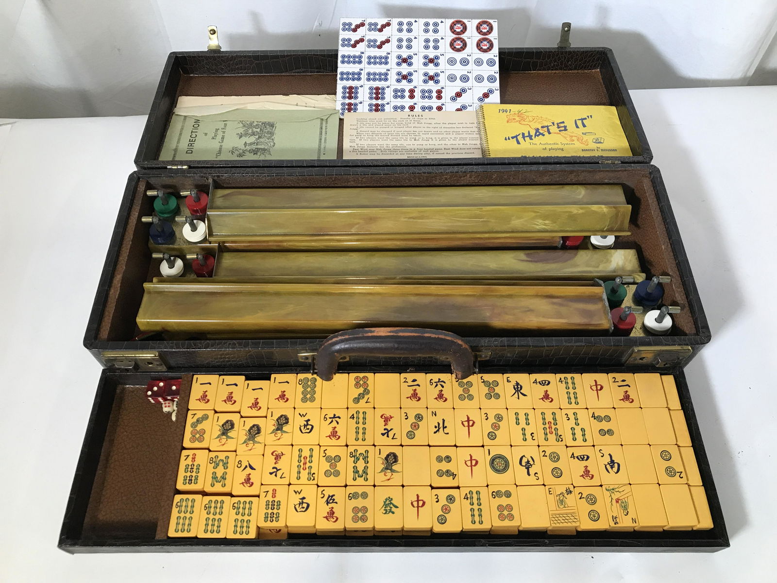 Antique Bakelite Mahjong Set W Case: Mahjong Set is antique. Pieces in case are Bakelite. Case appears to be leather. Set 258 pcs includes 148 Tiles 25 blue chips 35 red chips 25 green chips, 20 white chips 2 red & white dice, 3 small cr
