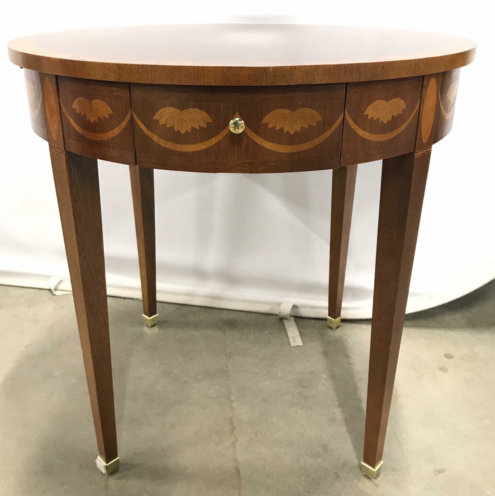 Vintage Round Inlaid Side Table W Brass Feet: Side table is round & wooden. Piece has 2 drawers and 2 pullout boards. Table has 4 legs each with gold toned brass feet. Piece appears to have inlaid detail on sides which mimics leaves & garland. Ta