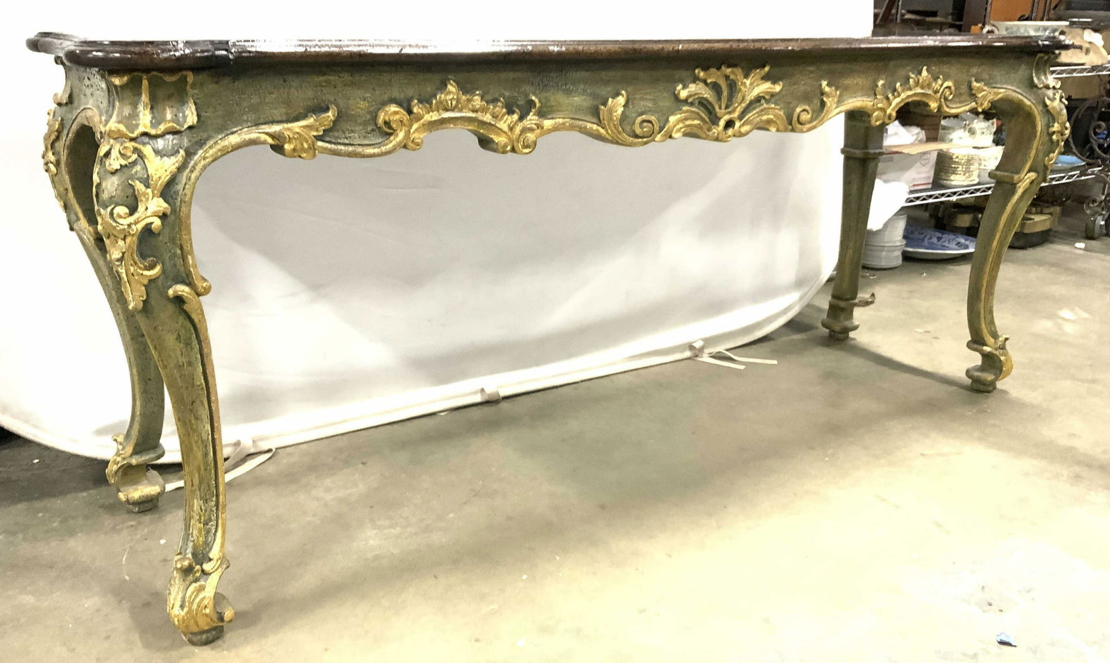 EMILIA INTERIORS Inc Ornate Wood Top Console Table: Underside has tag which reads EMILIA INTERIORS INC BROOKLYN NY. Table appears to be vintage possibly antique. Table base & legs have green & gold toned intricately carved c, s scroll and leaf detail.