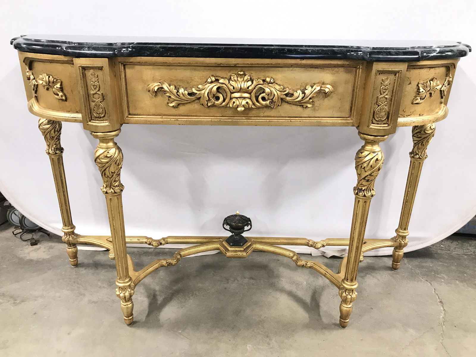 French Louis XVI G Leafed Marble Top Console Table: Console table appears to be antique. Piece is gold leafed with intricately carved detail. Tabletop is marble with green, black & white tones. Table has ornate carved detail with floral, leaf, C & S sc