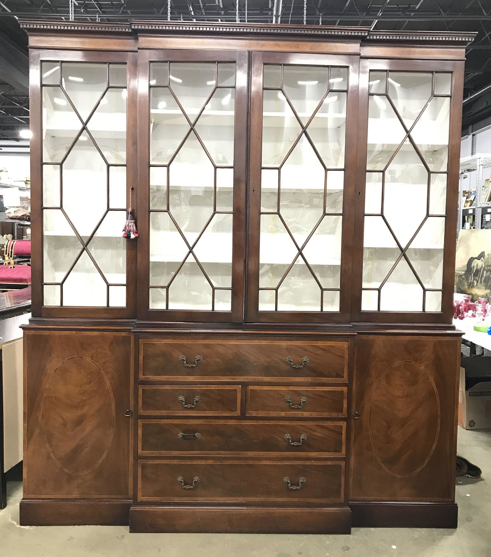 Vintage Windowed Wooden China Cabinet W Drawers: China cabinet is brown toned and wooden. Piece has 4 windowed display doors. Center area has 3 shelves, side display areas have 2 shelves each. Lower half of piece contains 5 drawers and 2 cabinet doo