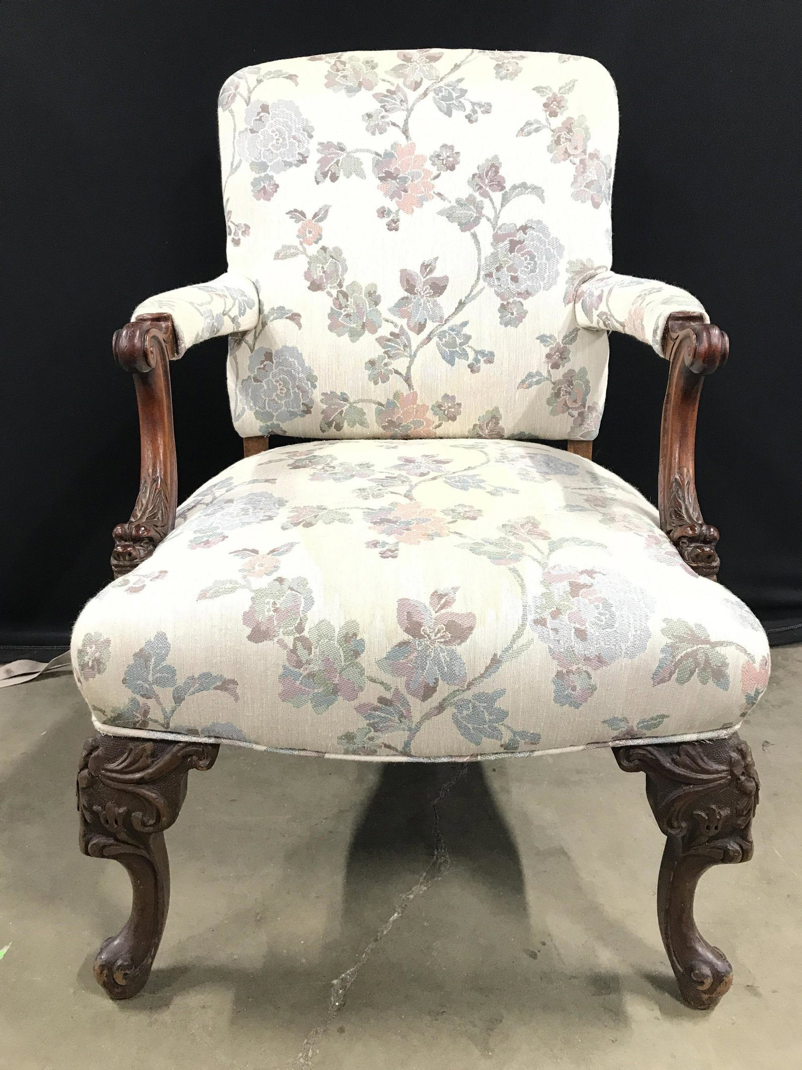 Vintage Carved Wooden Upholstered Bergere Chair: Bergere is upholstered with floral vine and leaf detail. Piece has intricately carved wooden detail. With 2 front Carved wooden Legs & feet. Armrests are upholstered. Ends of armrest upholstery have d
