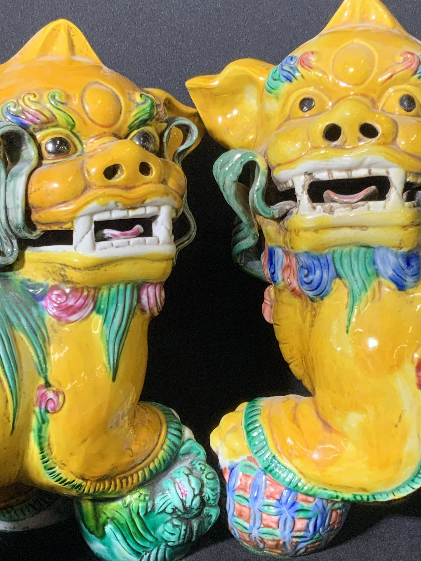 Pair Signed Vintage Asian Fu Dog Statues: Two vintage fu dogs / foo dogs / temple lions / temple guardians. Both foo dogs are ceramics with embossed ceramics detailing. Both hand painted. They are both glazed primarily yellow with accents of