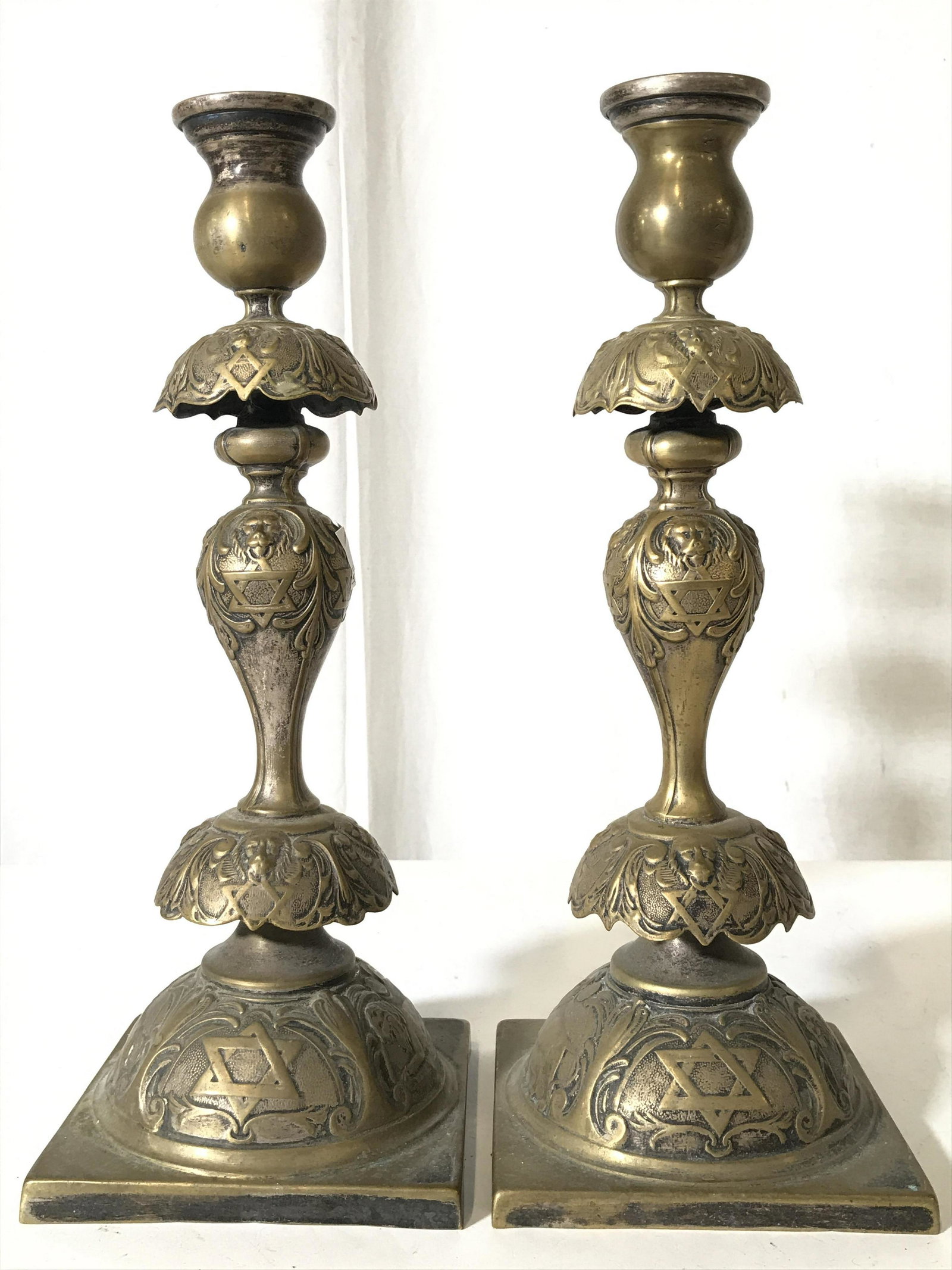 B HENNEBERG Pair Vintage Judaica Candlesticks: Underside is marked B HENNEBERG WARSZAWA. Each piece is gold toned and metal. Candlesticks are vintage possibly antique. Candlesticks have Star of David and ornate detail. Candlesticks also have lionh