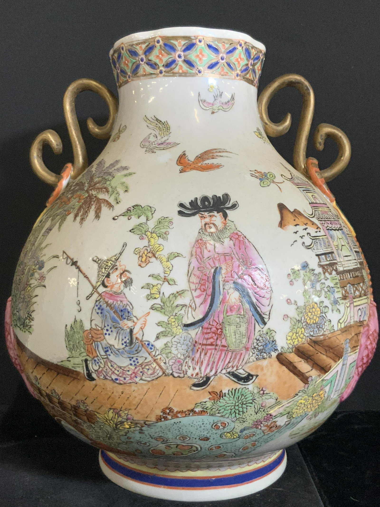 Vintage Signed Asian Twin Handle Porcelain Vase: Porcelain vase decorated with twin gilded handles and embossed carp to the sides. In relief accents to the rim of vase and throughout foliage and birds. People depicted on each side. In one scene they