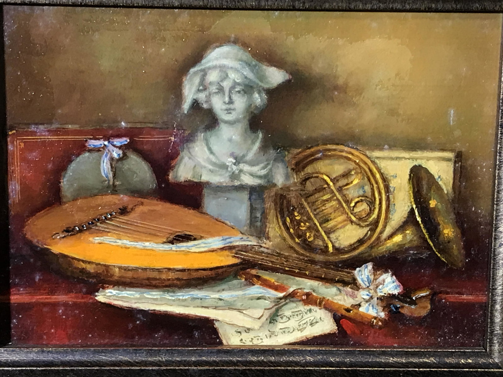 Oil on Board Still Life Painting: Oil on board still life painting, no apparent signatures, stamp to reverse too faded to read, subject a still life consisting of a bust a trumpet and a lute with sheet music on a red table, hand carve