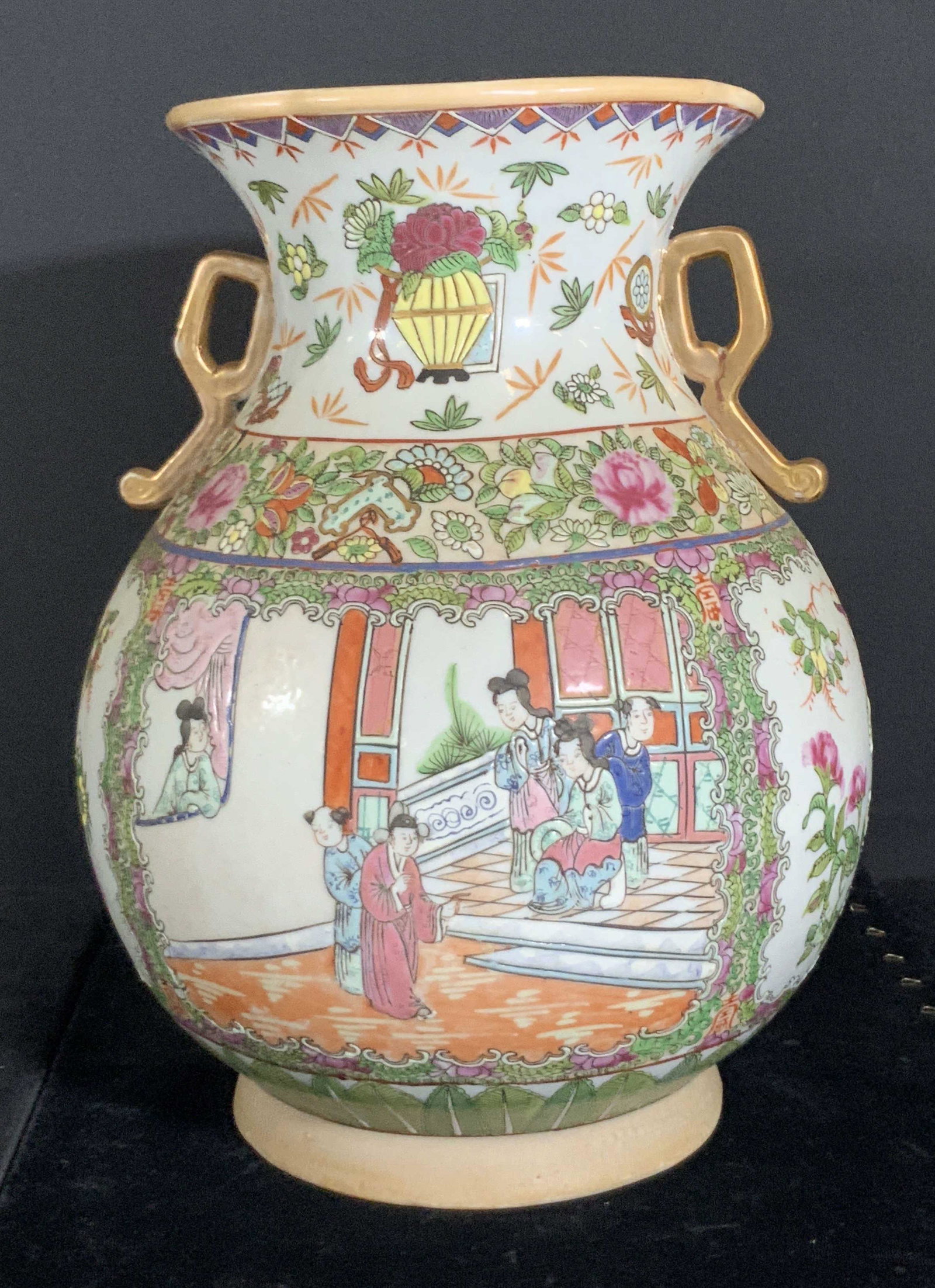 Vintage Signed Asian Porcelain Vase, Hong Kong: Porcelain vase decorated with twin gilded handles. In relief accents to the rim of vase and throughout foliage, birds, and people. Hand painted people depicted on each side wearing traditional clothin