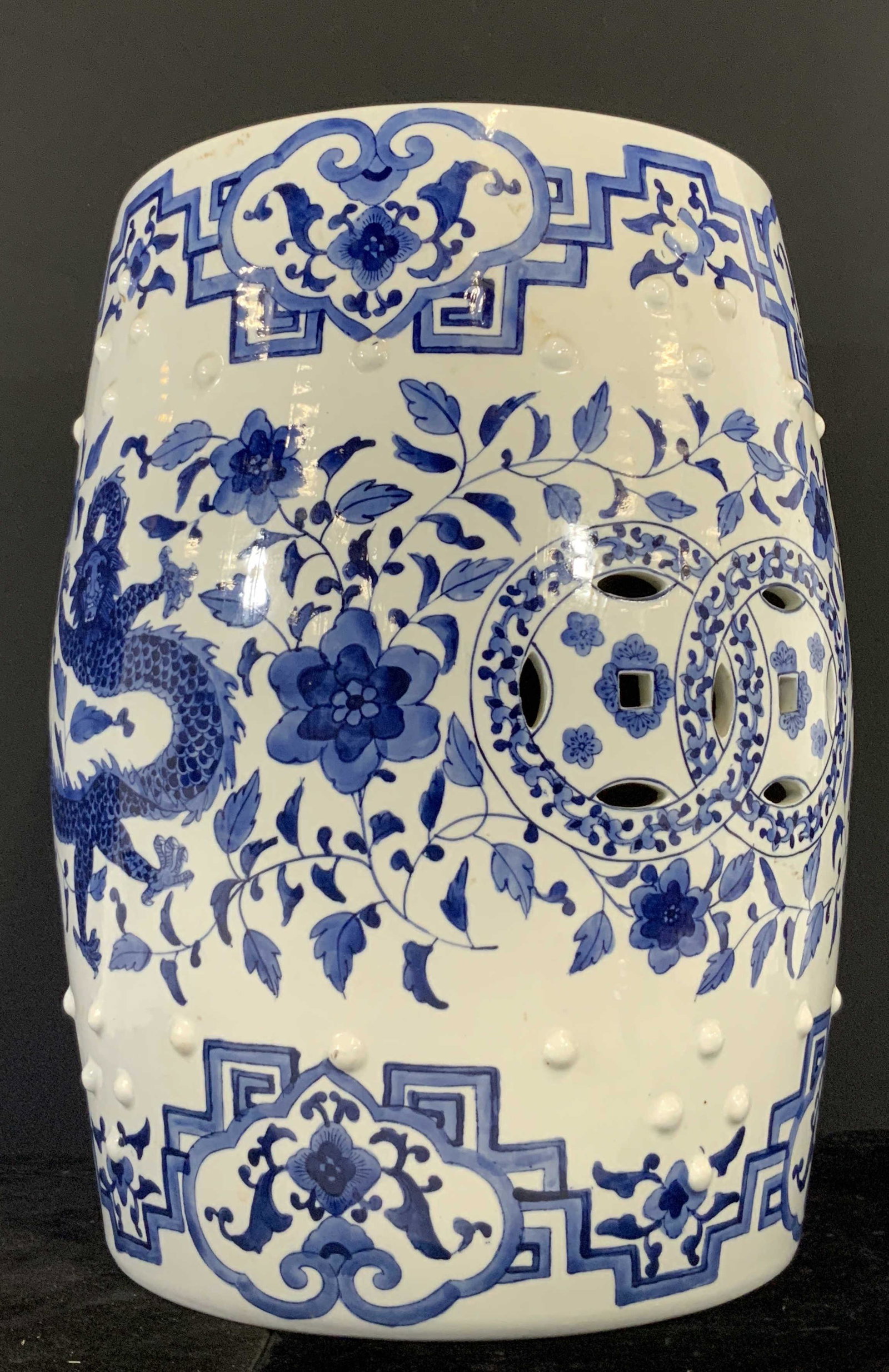 Asian Blue & White Porcelain Garden Stool: Hand painted Blue and white porcelain garden stool featuring floral and dragon designs. Pierced porcelain top and sides, embossed porcelain hob nob design throughout. Piece has weight. Approx. Height 