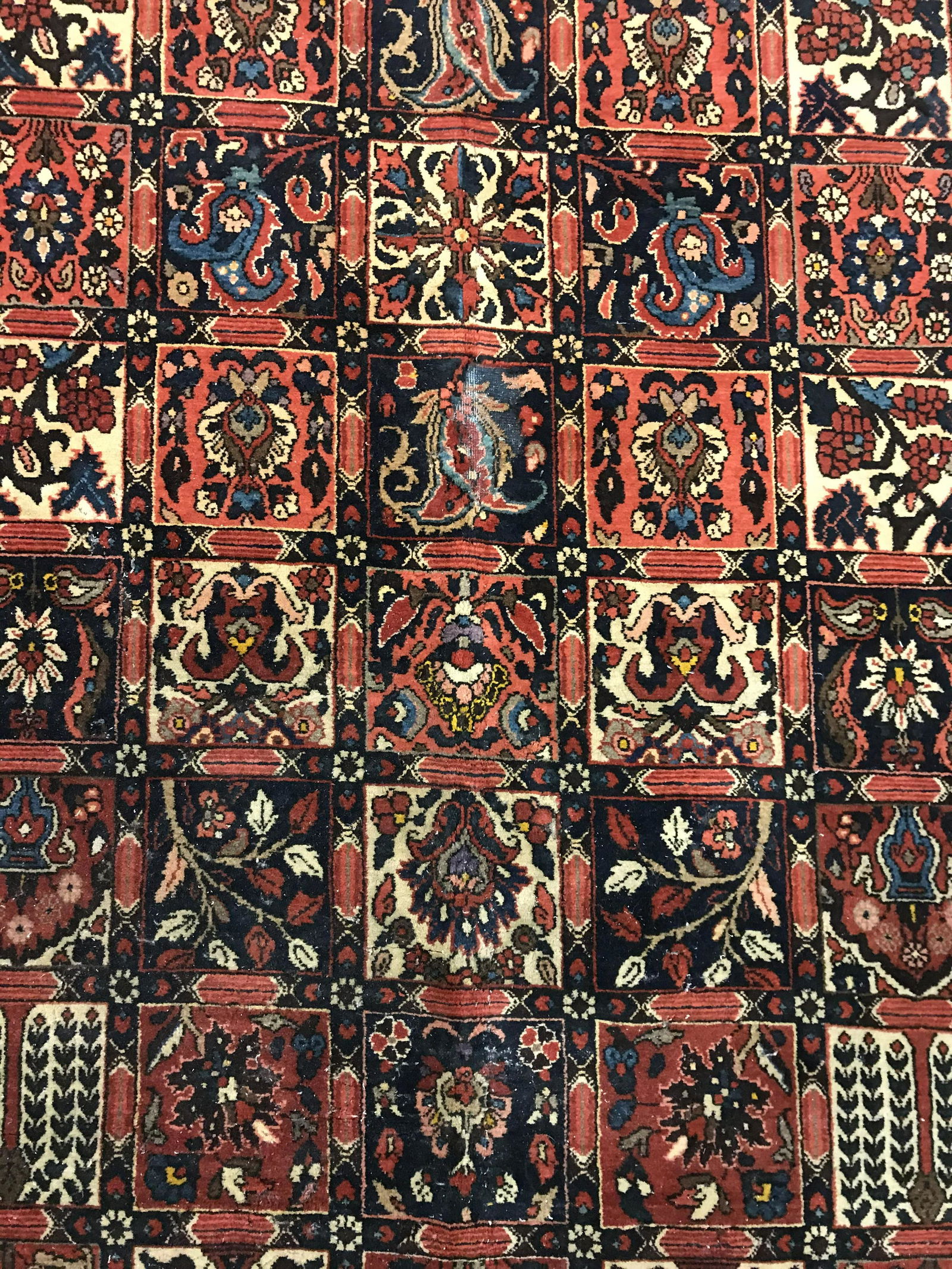 Antique Persian Area Rug: Antique, possibly vintage, area rug. All over floral pattern decorates rug, multi toned pattern, on crimson base. Measures approx 81 inches W, 120 inches Long. Ends are frilled. Wear is consistent wit