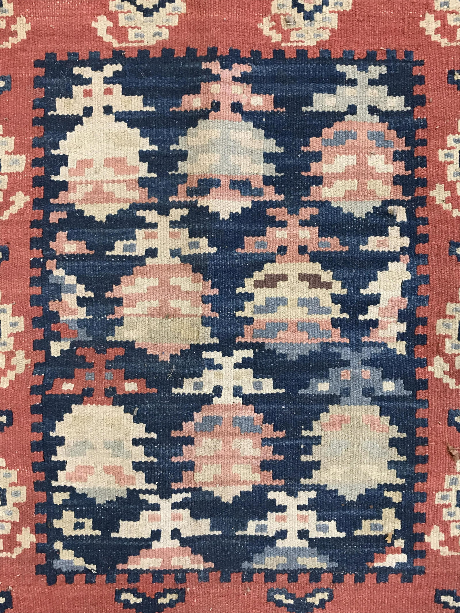 Vintage Fringed Area Rug: Vintage hand made wool carpet. Ends are fringed. Colored in orange and blue tones. Measures approx 36 inches long, 22 inches W. Wear is consistent with age and use. Carpet, welcome mat, area rug, area