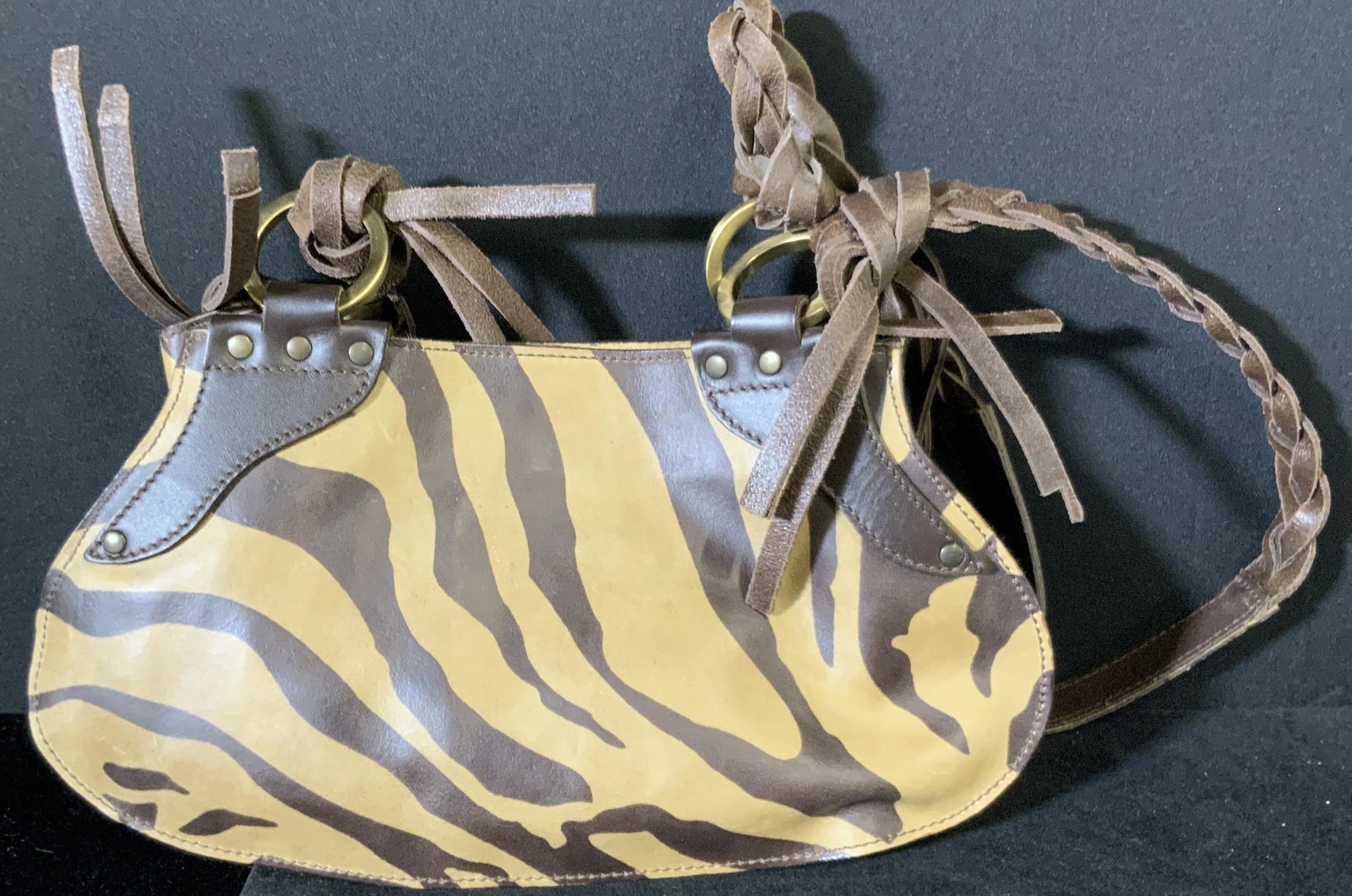 TOSCA BLU Braided Zebra Stripe Purse, Italy: A deep brown and beige zebra striped purse with braided straps. The interior is lined with brown fabric that reads: Tosca Blu. Interior tag reads: Made in Italy. Interior has two pockets, one zippered
