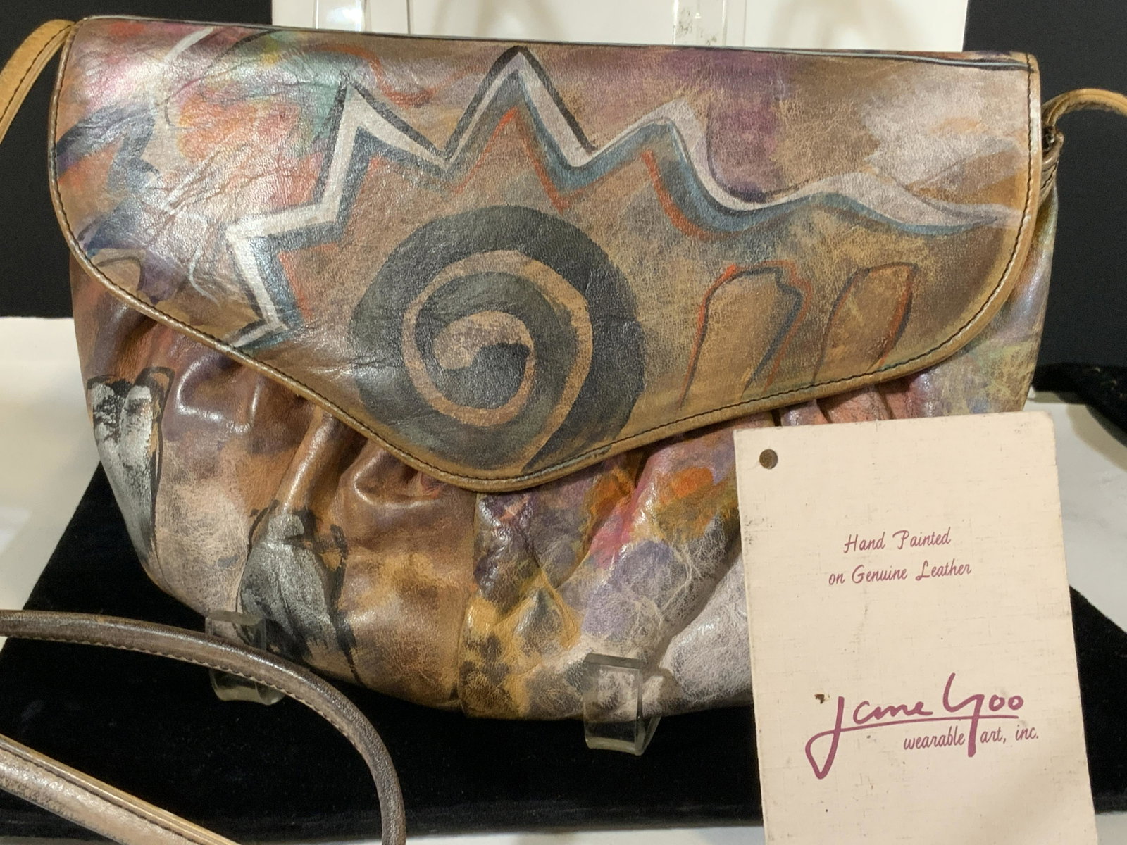 JANE YOO Vntg Hand Signed Bag, Org Tag: Designer Jane YOO ( Los Angeles) hand painted leather bag with handwritten signature in marker with copyright symbol under flap. Comes with original 1986 product card. 10 x 7 in. Long strap hangs 26 i