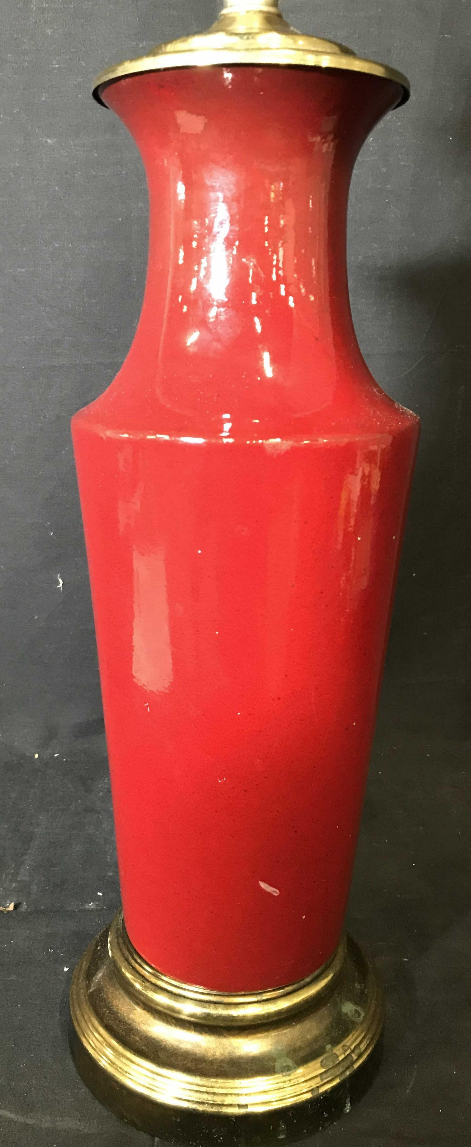 Red Toned Porcelain Table Lamp W Metal Base: Lamp is red toned, appears to be porcelain. Lamp has gold toned metal base, possibly brass. Lamp includes harp. Measures approximately 3d inches tall 6.5 inches wide. Lamp, porcelain lamp, table lamp,