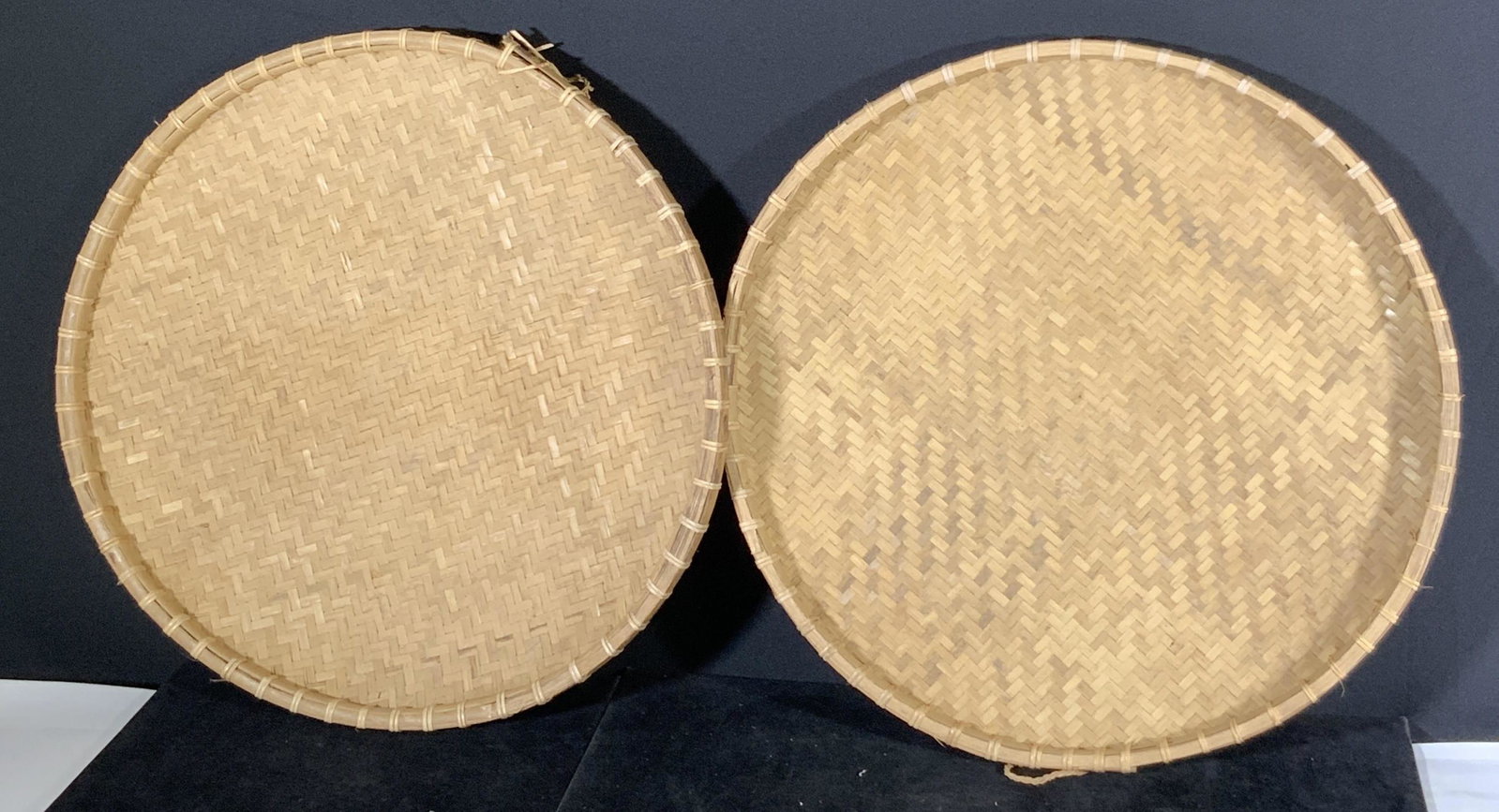 Pair Handmade Asian Woven Bamboo Basket Trays: 2 circular handmade woven bamboo basket trays. Originally used for drying herbs, flowers, and more. One small woven handle on each basket. Can be used as a decorative display basket, hanging wall art,