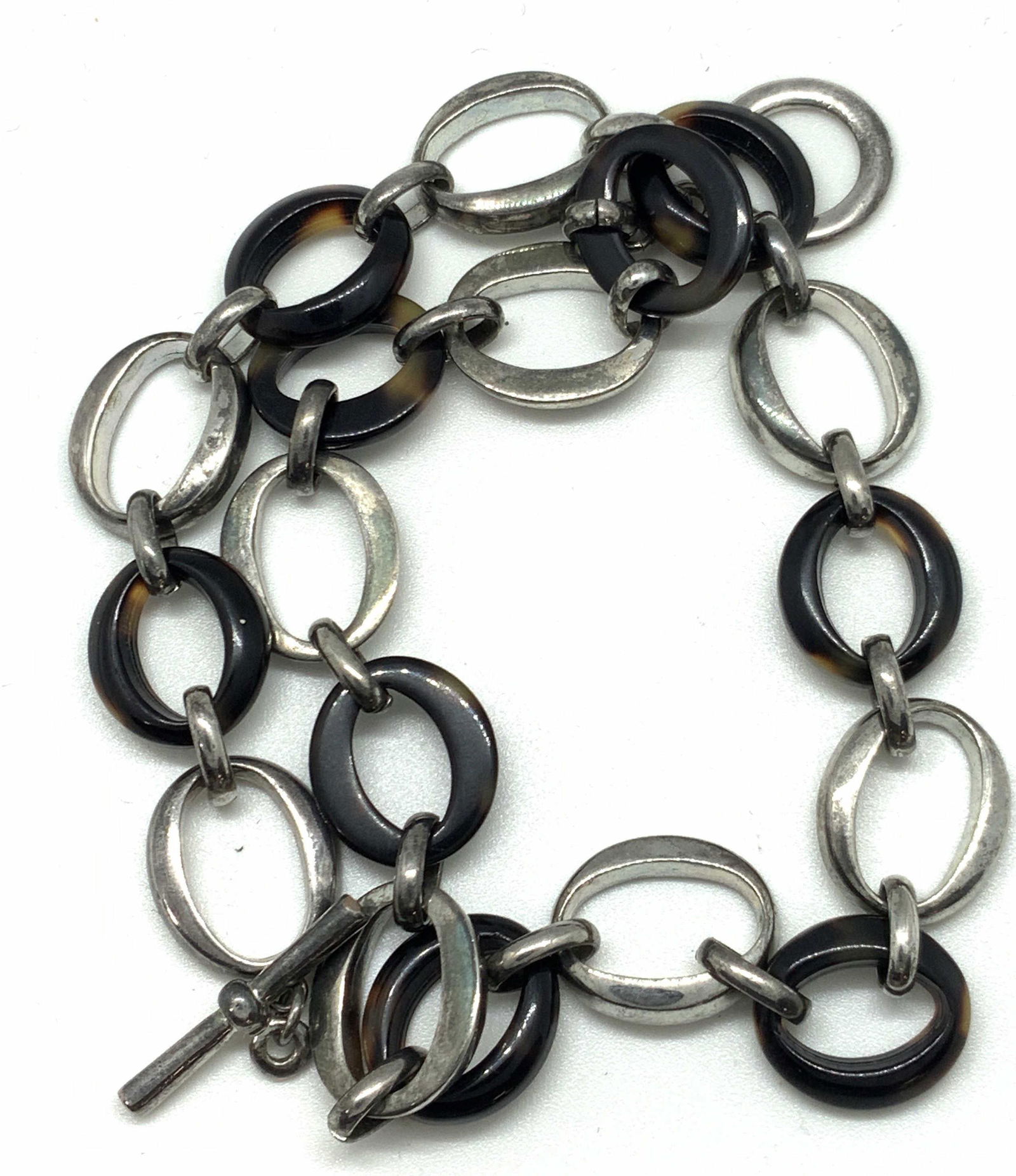 Silver Tone Tortoise Shell Style Necklace Jewelry: Polished silver toned and tortoise shell style circles connected via small links. Choker style necklace. The necklace has a circle and bar closure. Approx. Diameter of necklace closed is 5 in. Approx.