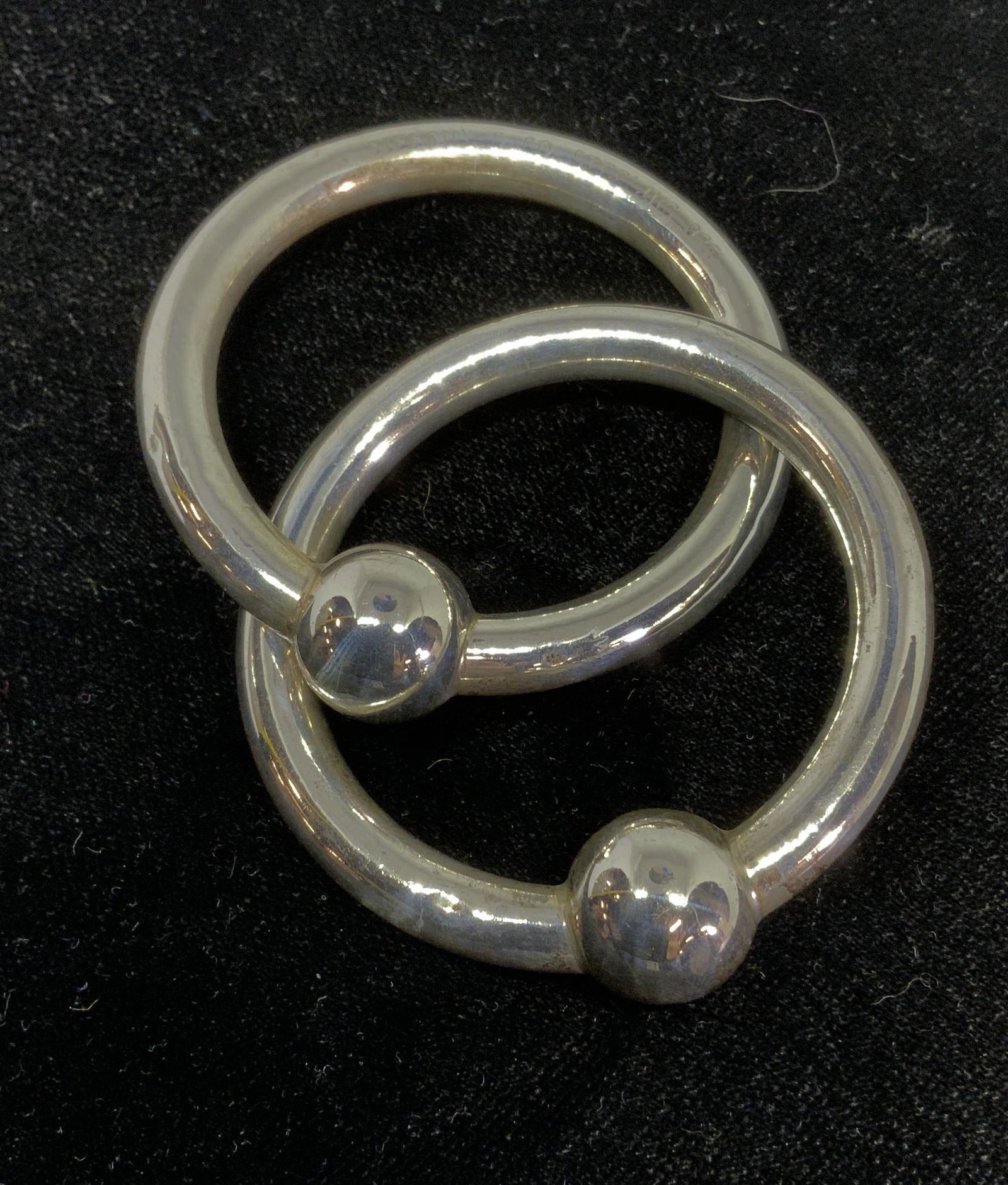 TIFFANY & Co. Sterling Silver Baby Rattle: Baby Rattle 2 rings linked together, each with an ornamental sphere at center top. 2 1/8 in diameter. Signed TIFFANY & CO and reads STERLING 925. Weight 1.07 ozt Vintage Tiffany. Luxury Estate Baby Ac